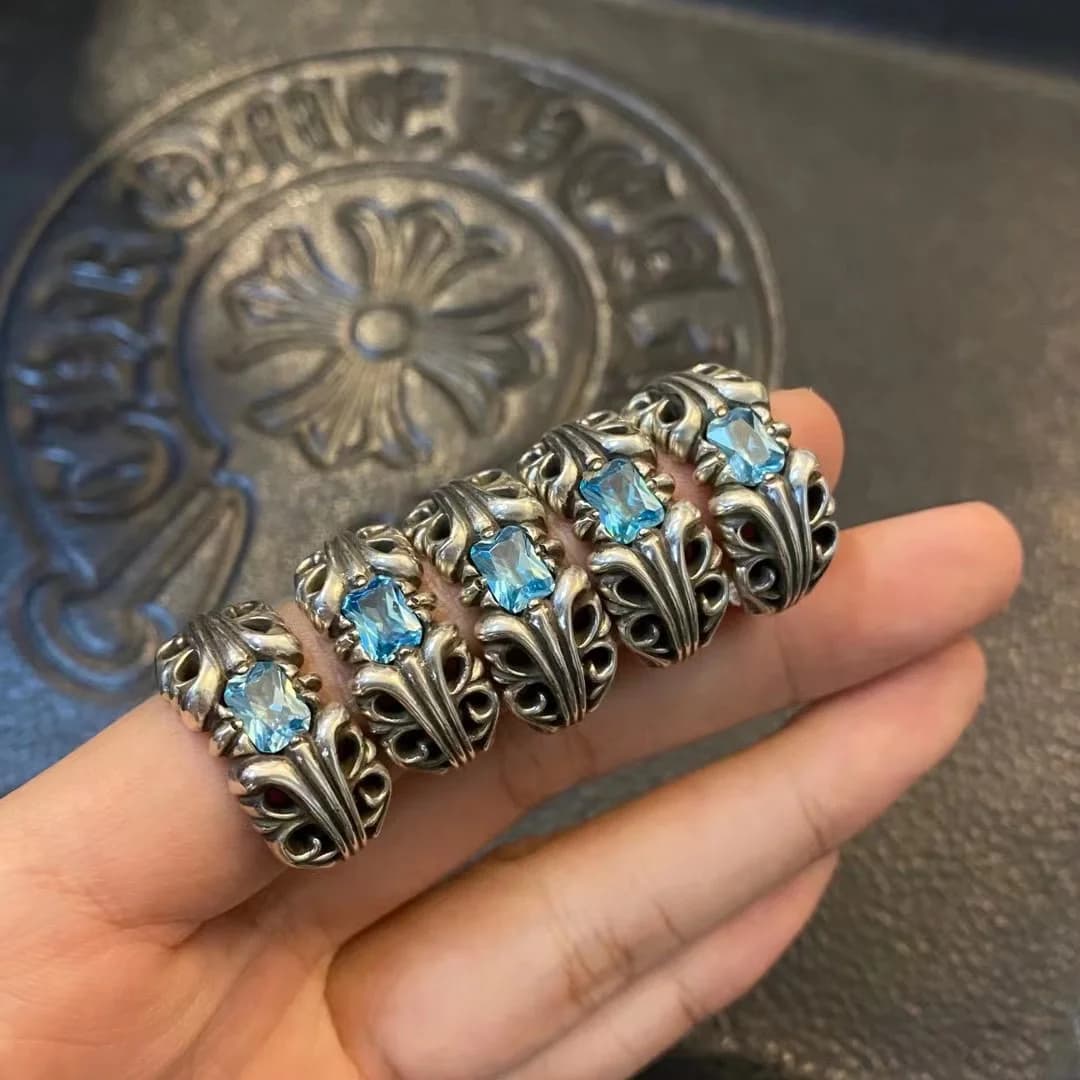 Несколько колец Chrome Hearts с голубыми кристаллами на руке