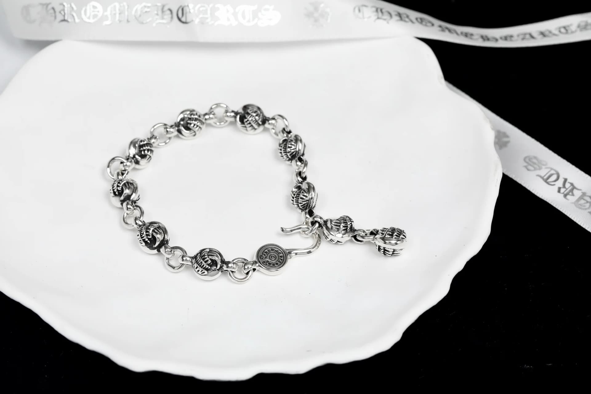 Серебряный браслет Chrome Hearts с фигурными звеньями на белой подставке