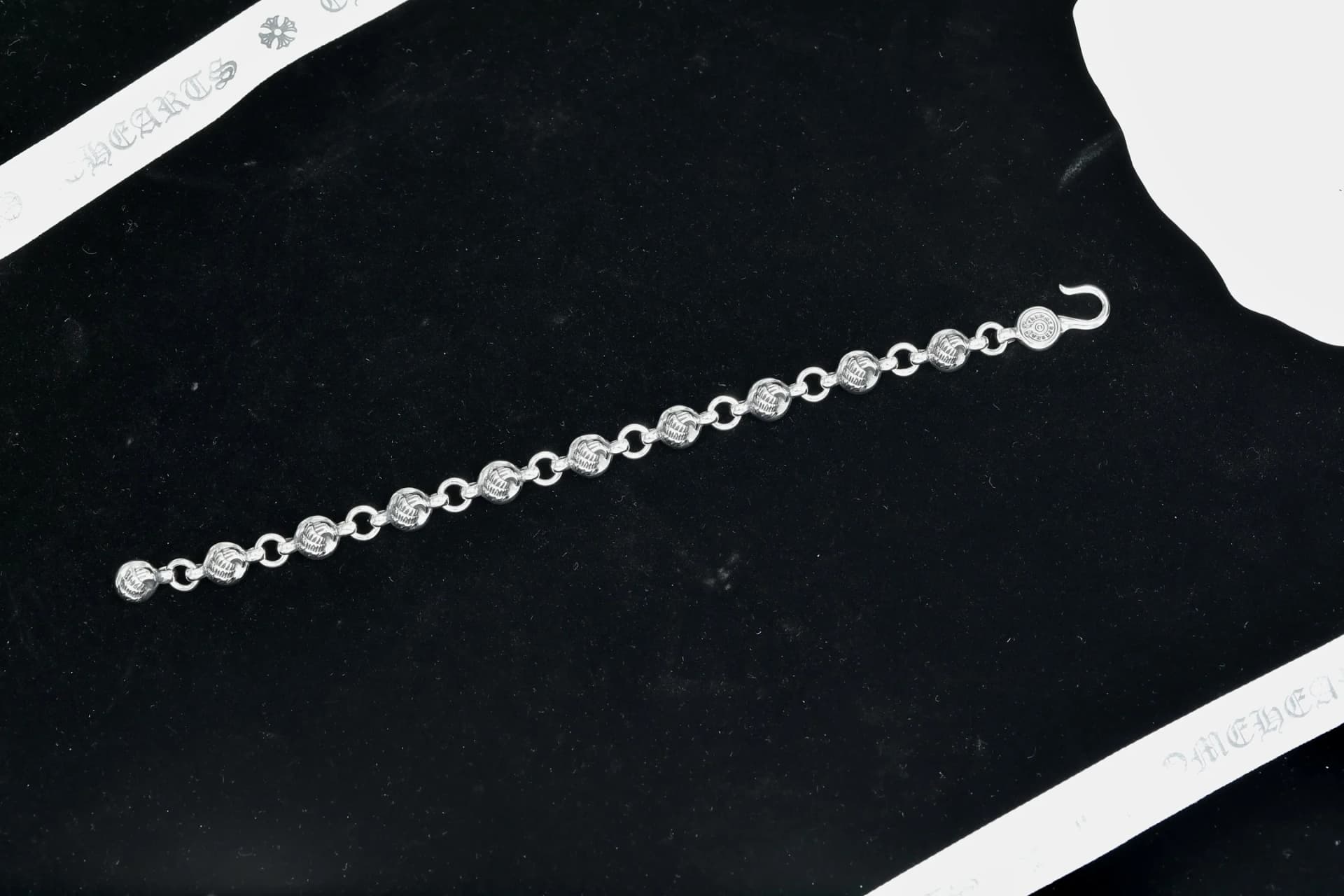 Серебряный браслет Chrome Hearts в развернутом виде на темном фоне