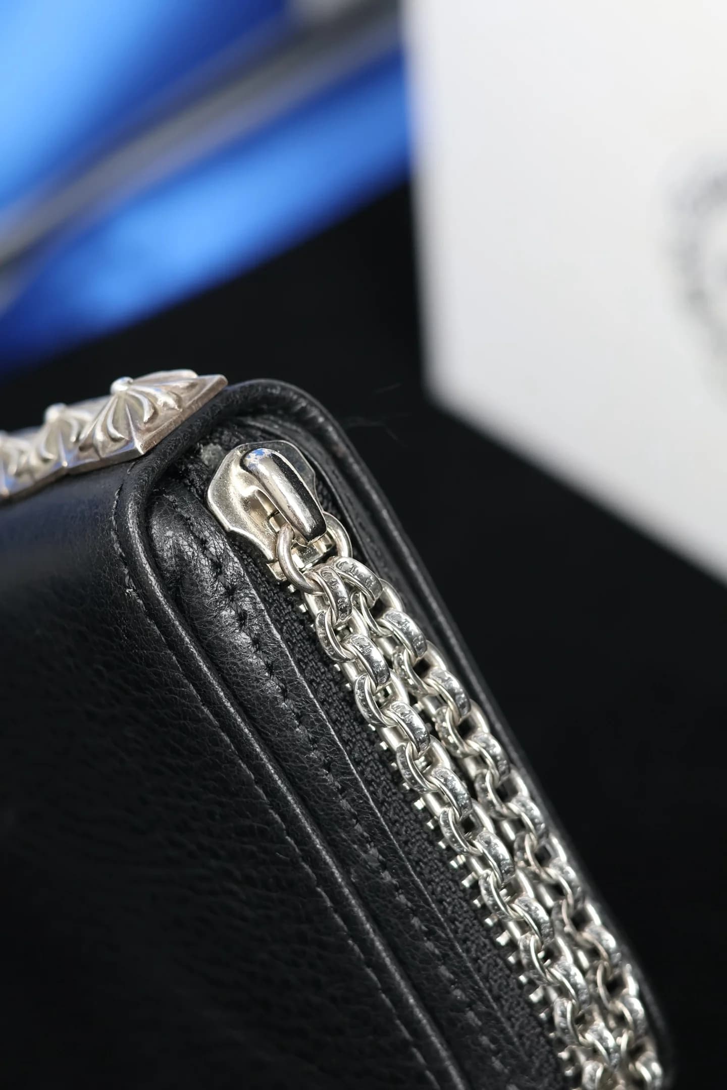 Крупный план бегунка молнии и серебряных цепочек кошелька Chrome Hearts