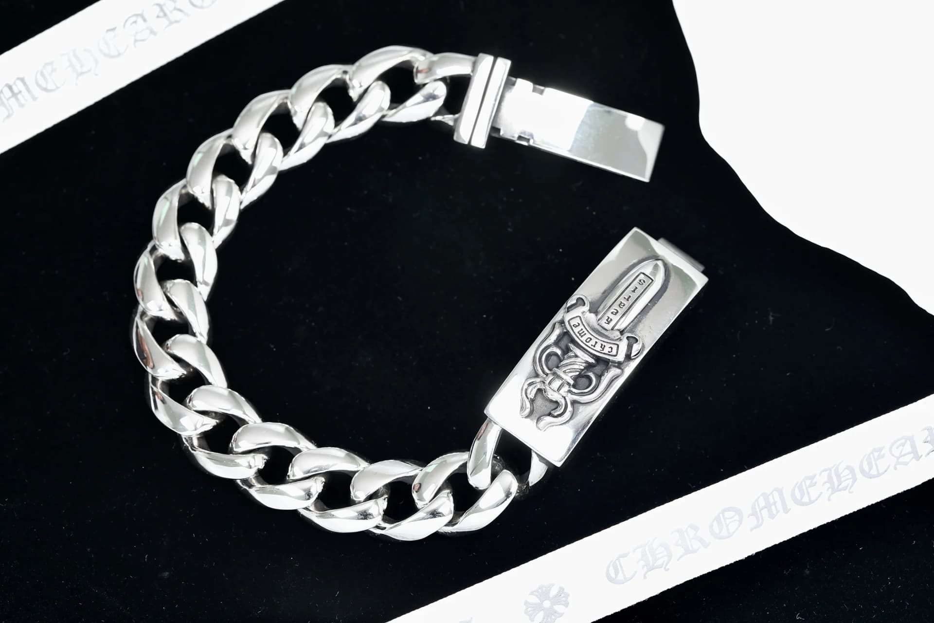 Серебряный браслет-цепь Chrome Hearts Dagger ID в расстегнутом виде на черном фоне