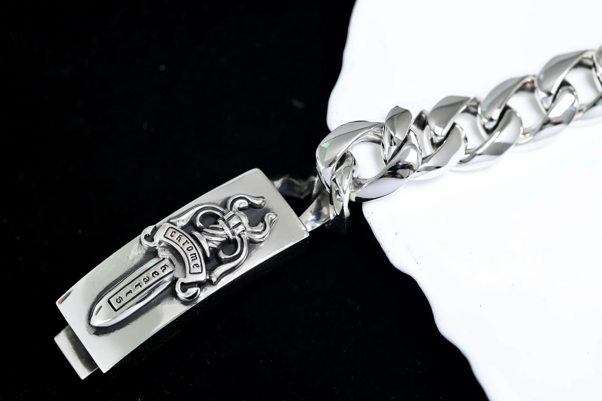 Крупный план замка браслета с рельефным кинжалом Chrome Hearts