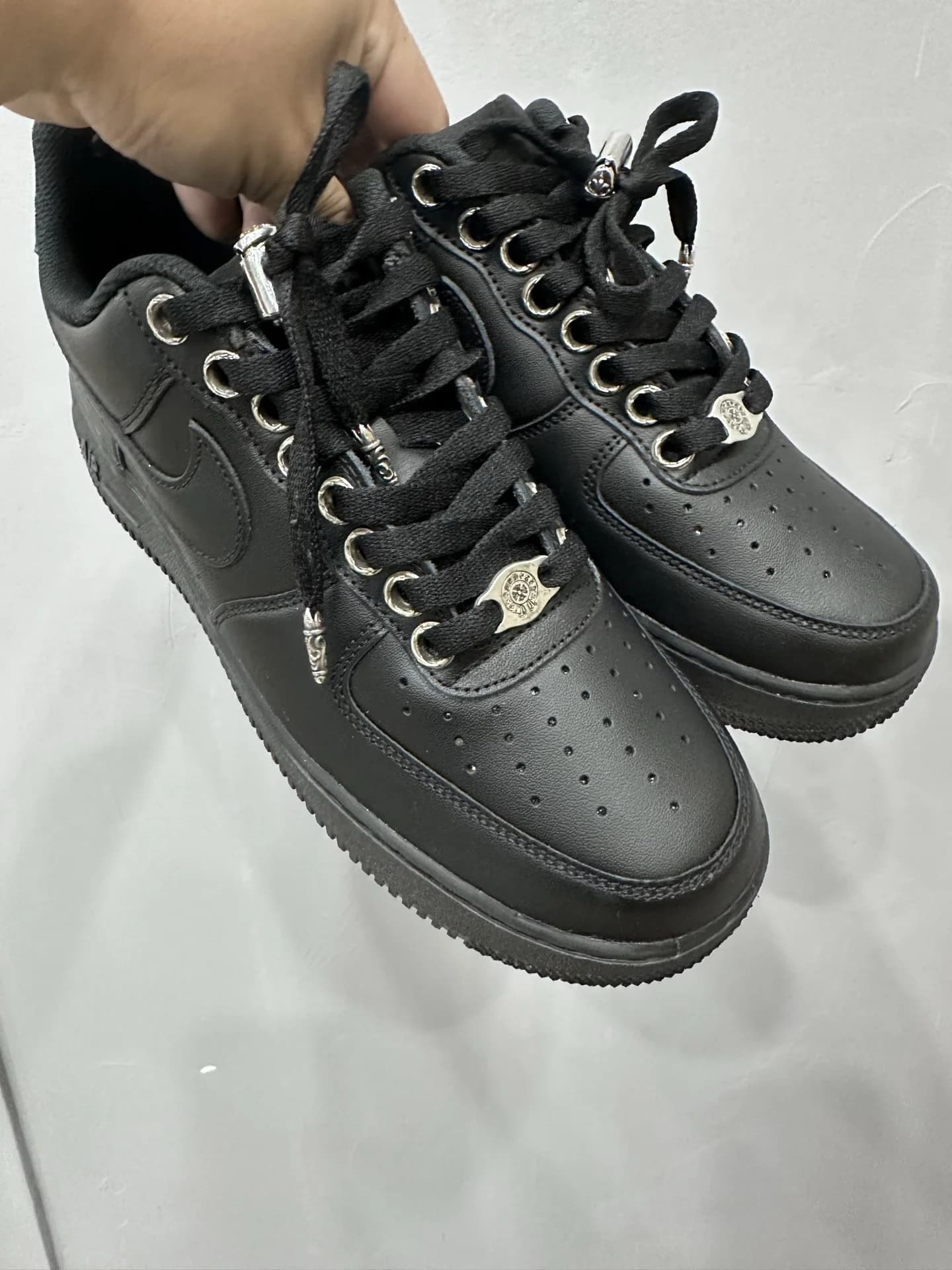 Черные кроссовки Chrome Hearts x Nike Air Force 1 в руках