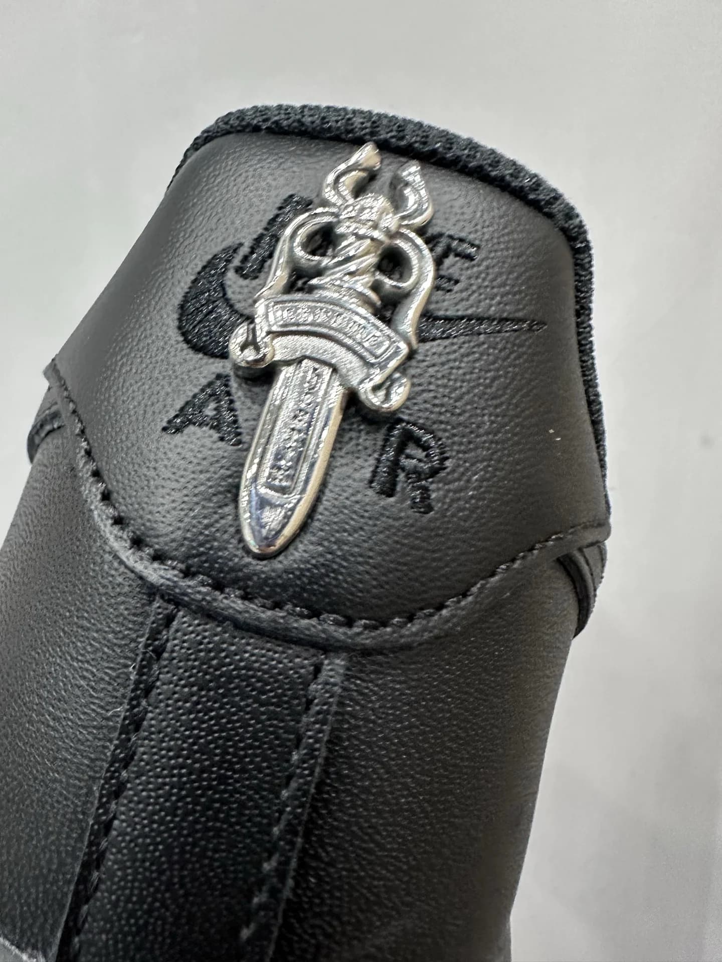 Крупный план серебряного кинжала на заднике кроссовка Chrome Hearts x Nike Air Force 1