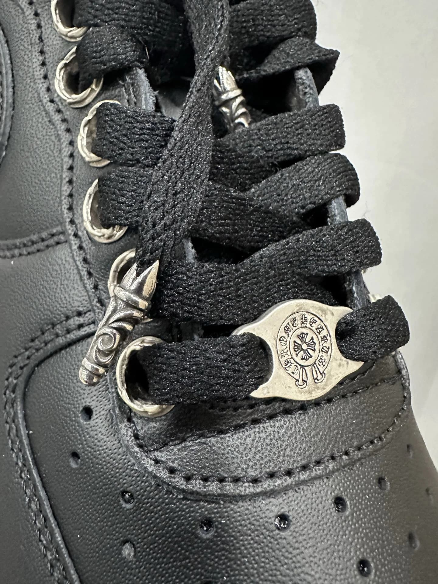 Крупный план шнуровки и серебряного дюбре Chrome Hearts