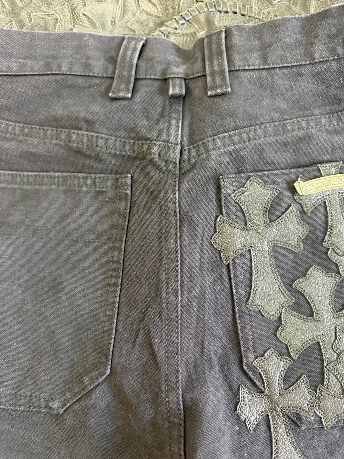 Крупный план нашивок-крестов на чёрных карго Chrome Hearts