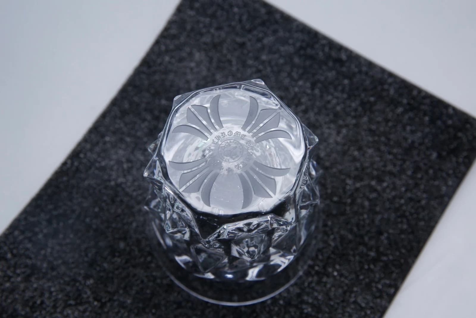 Крупный план дна стакана с гравировкой Baccarat и Chrome Hearts