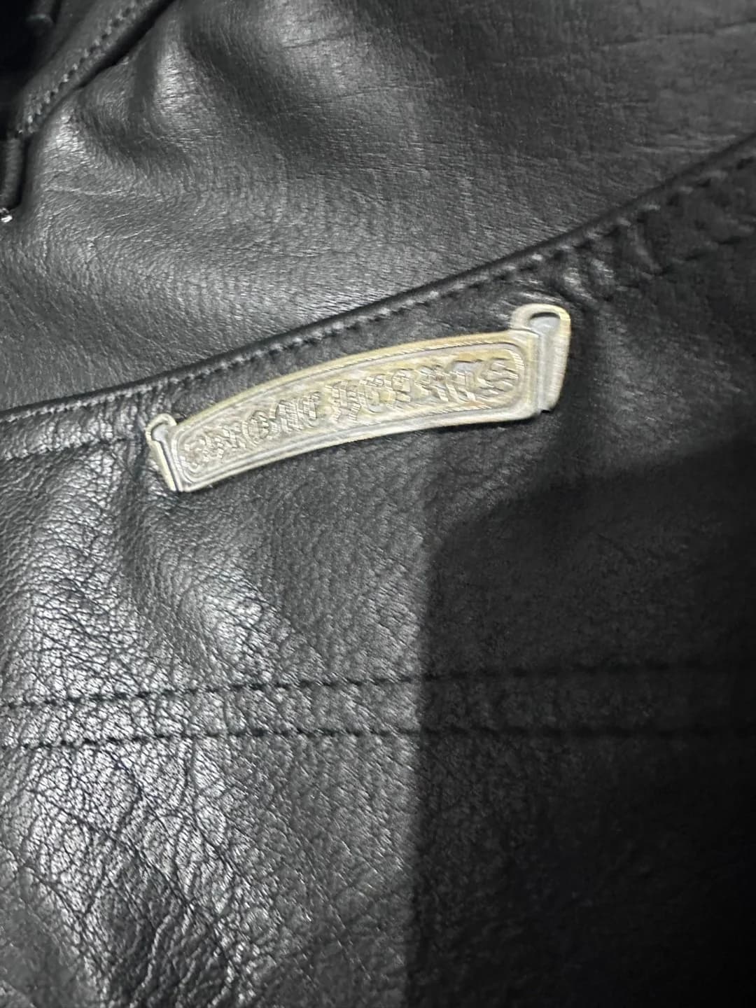 Металлическая пластина с логотипом Chrome Hearts на задней части брюк