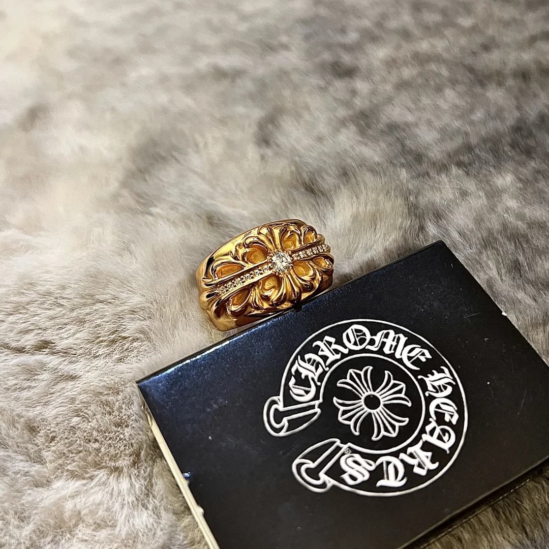Золотистое кольцо Chrome Hearts Keeper с инкрустацией камнями рядом с коробкой