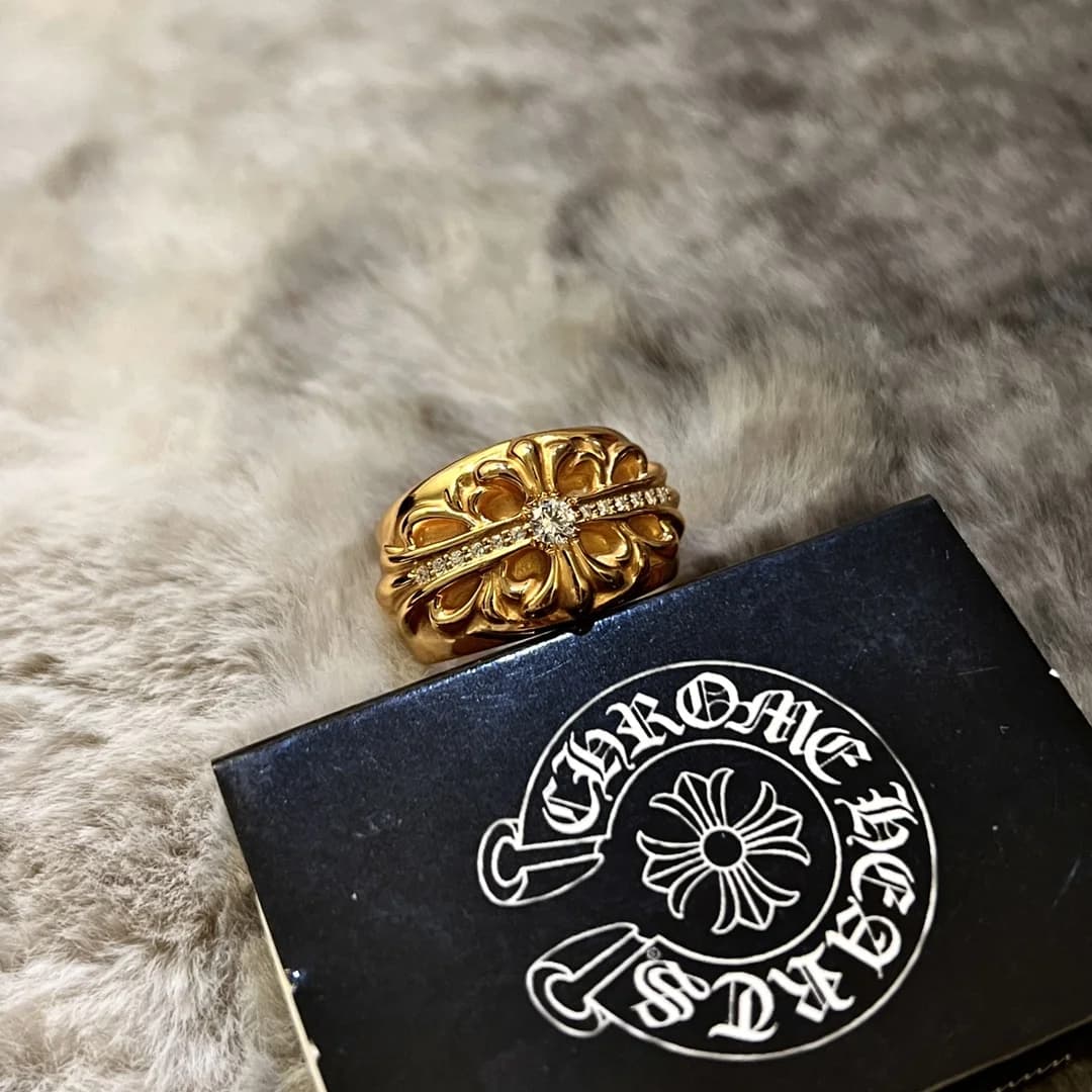 Крупный план узора и кристаллов на золотом кольце Chrome Hearts Keeper
