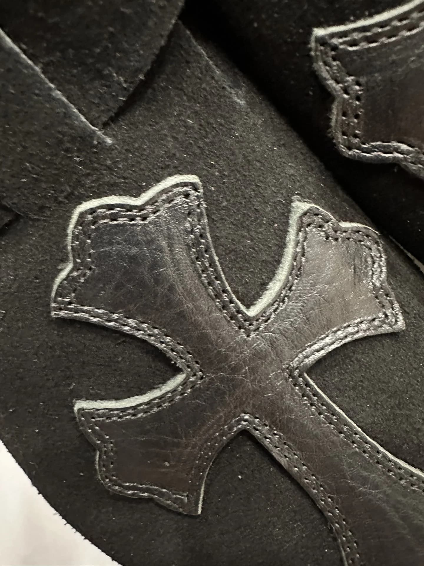 Деталь кожаной нашивки в виде креста на сабо Chrome Hearts x Birkenstock