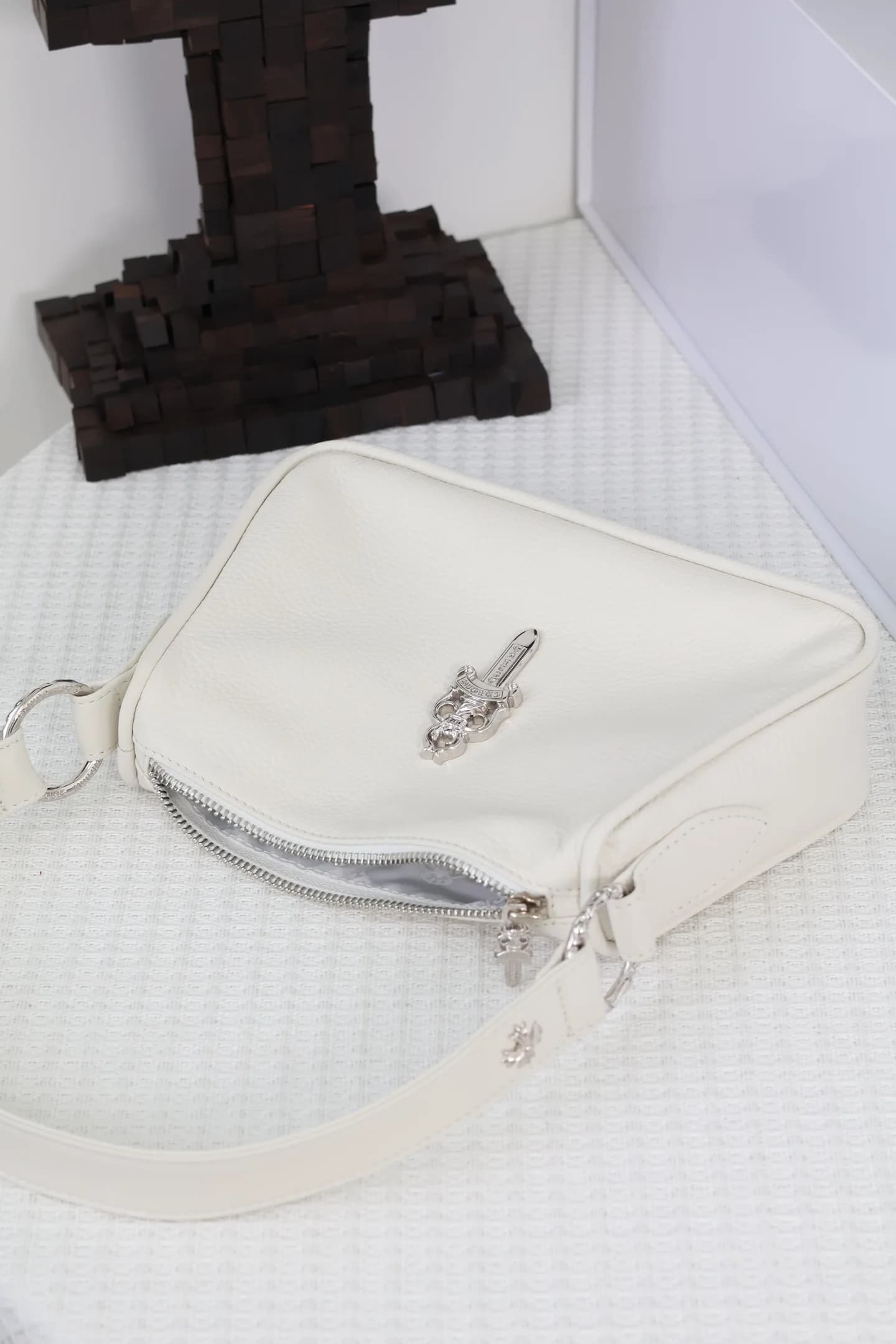 Вид сверху на молнию и конструкцию белой сумки Chrome Hearts