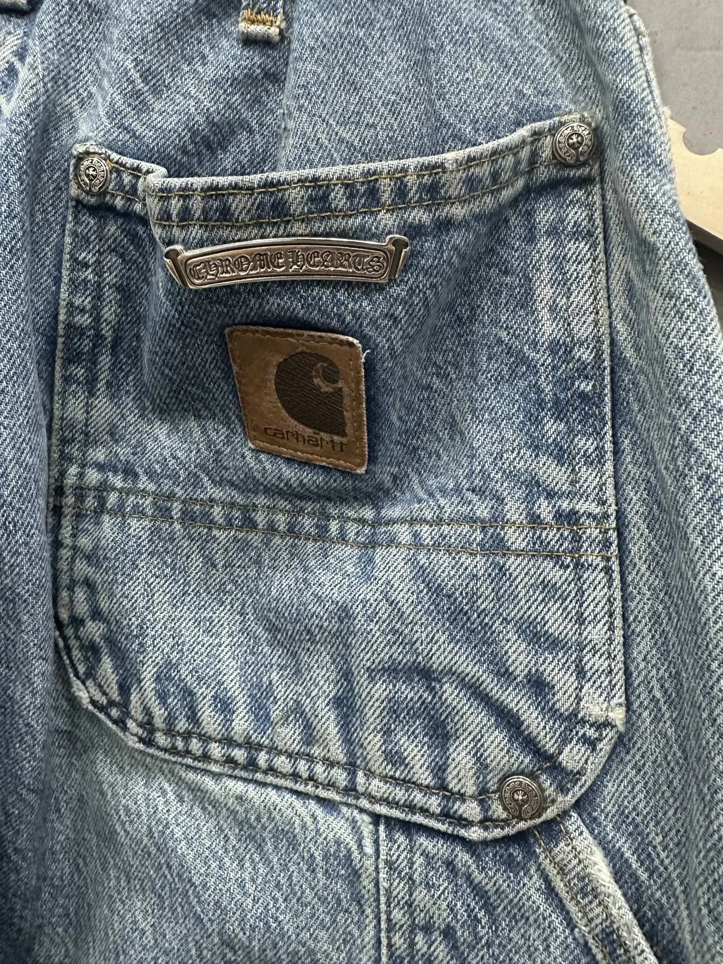 Задний карман джинсов с кожаным патчем Carhartt и серебряной пластиной Chrome Hearts