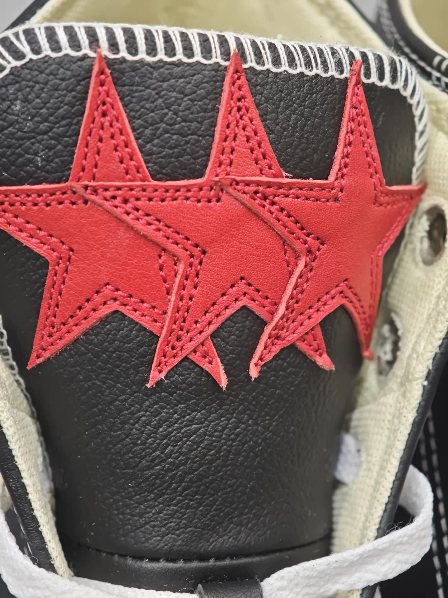 Крупный план язычка кед Chrome Hearts x Converse All Star с красными кожаными звездами