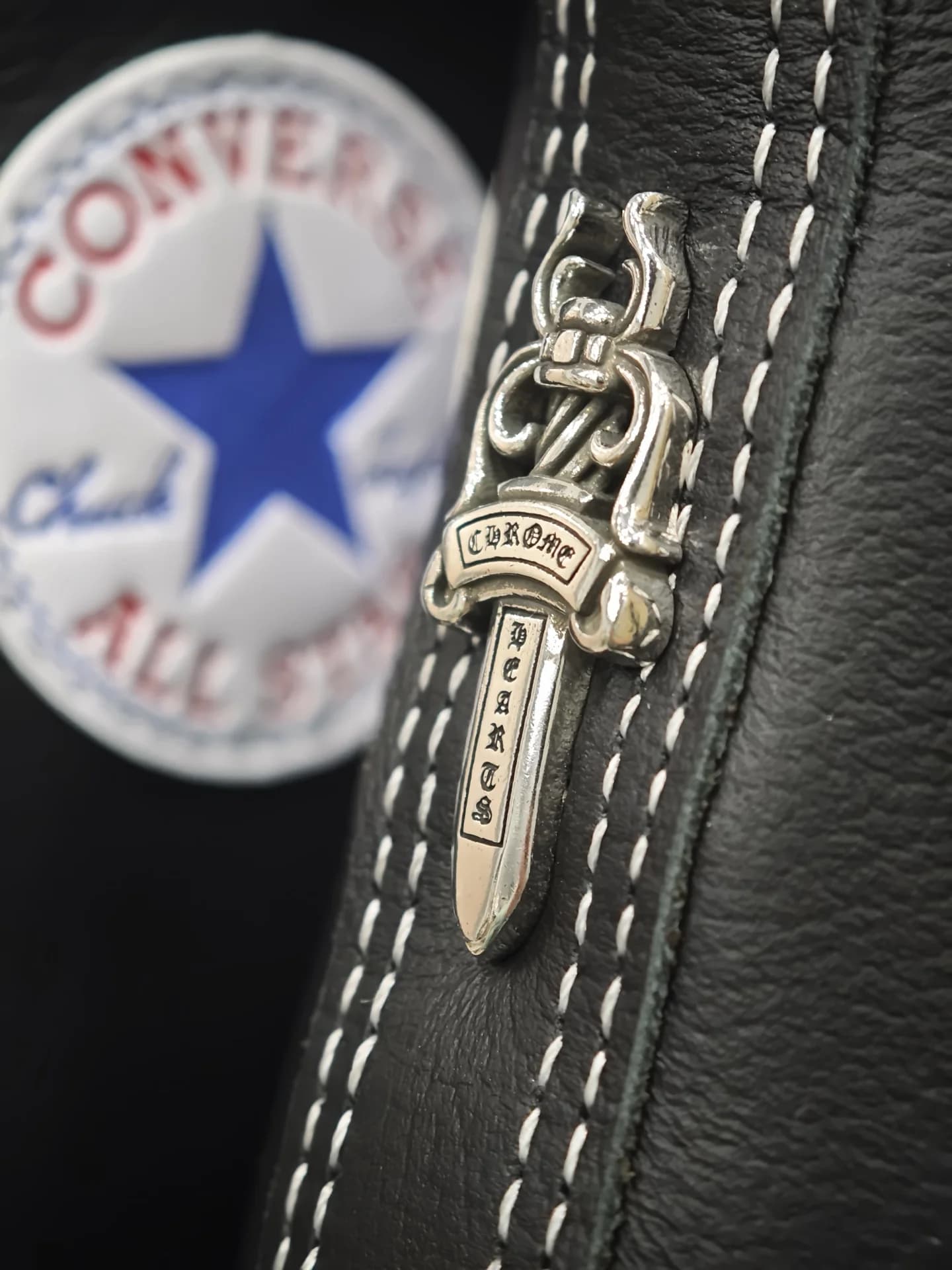 Деталь серебряной фурнитуры Chrome Hearts в виде кинжала на заднике кед Converse