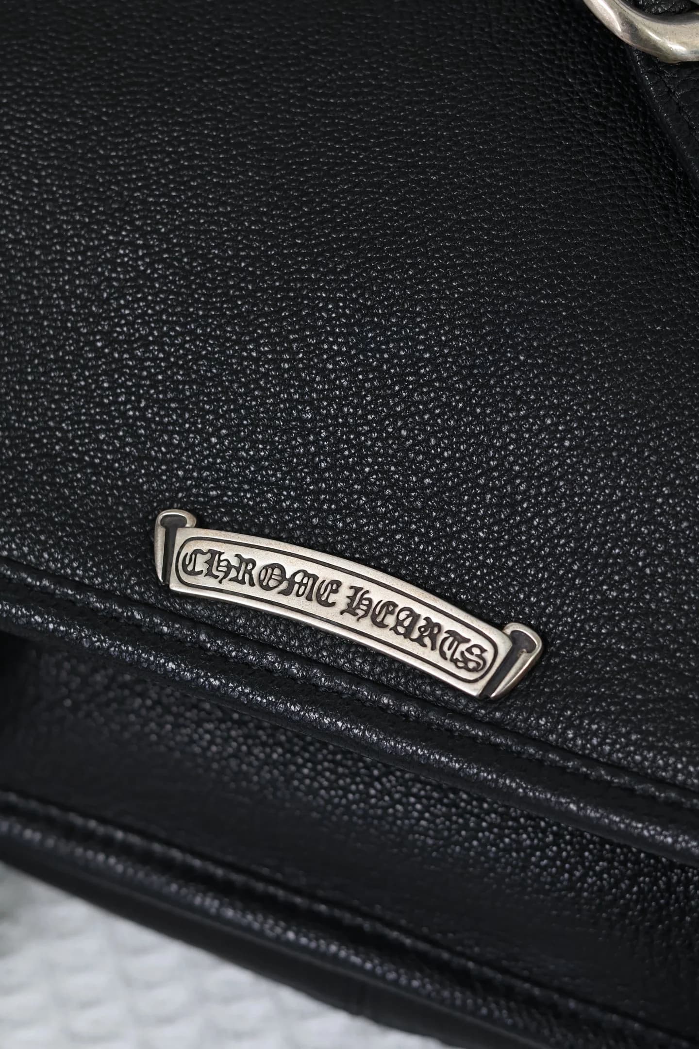 Серебряная плашка с гравировкой Chrome Hearts на клапане сумки