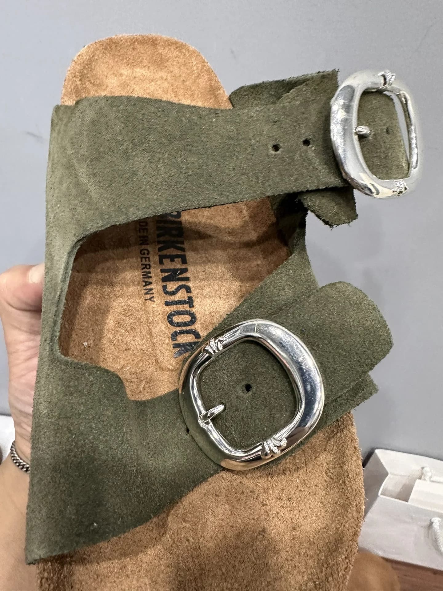 Крупный план серебряных пряжек на ремешках шлепанцев Chrome Hearts x Birkenstock Arizona