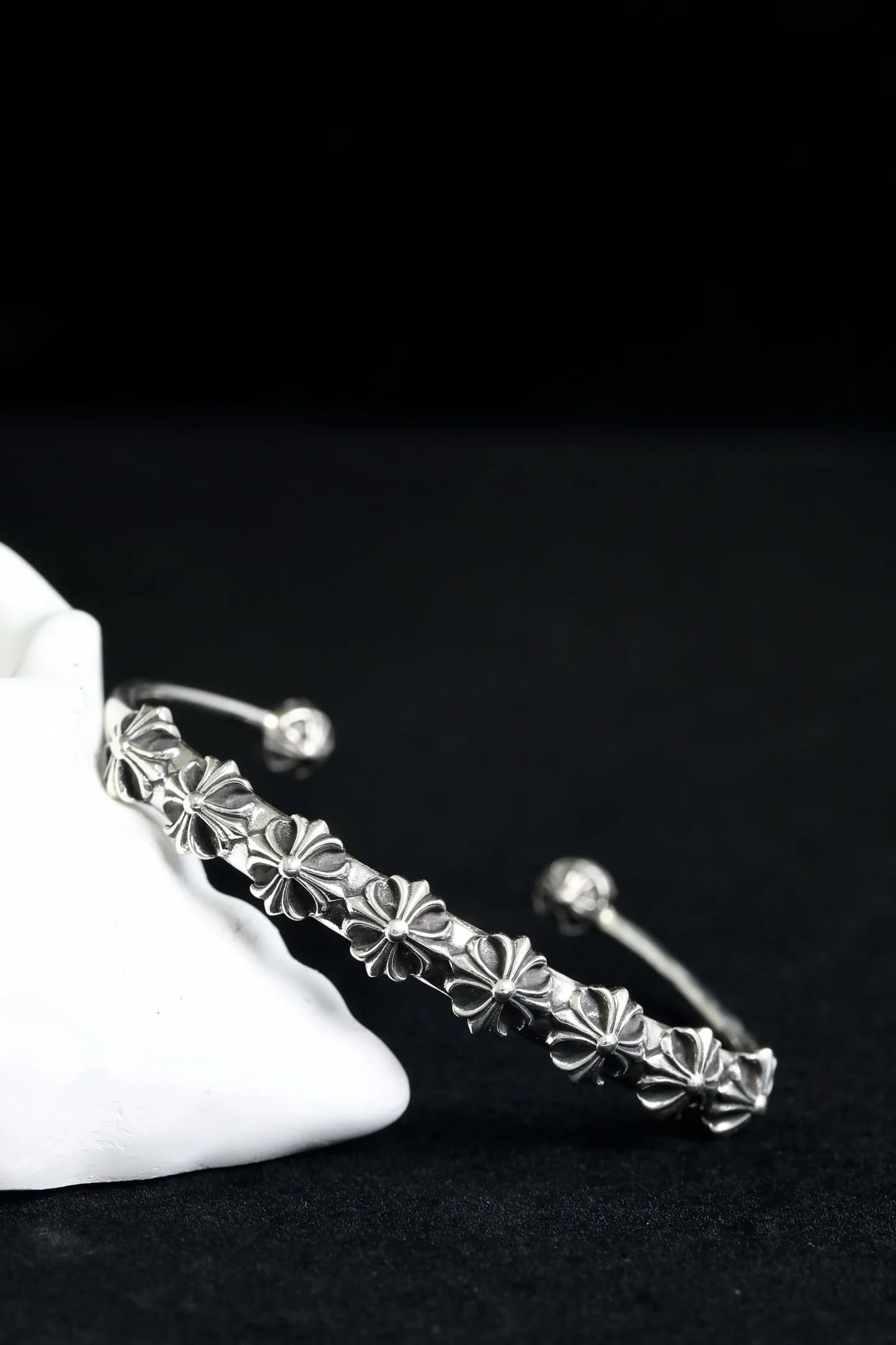 Крупный план фактурного узора с готическими крестами на браслете Chrome Hearts