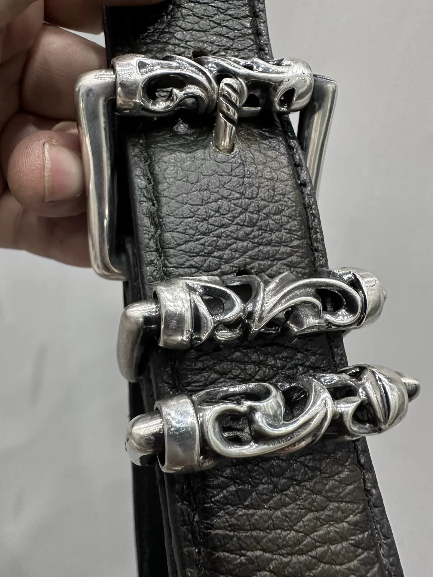 Крупный план серебряных шлевок Roller с готическим орнаментом на ремне Chrome Hearts