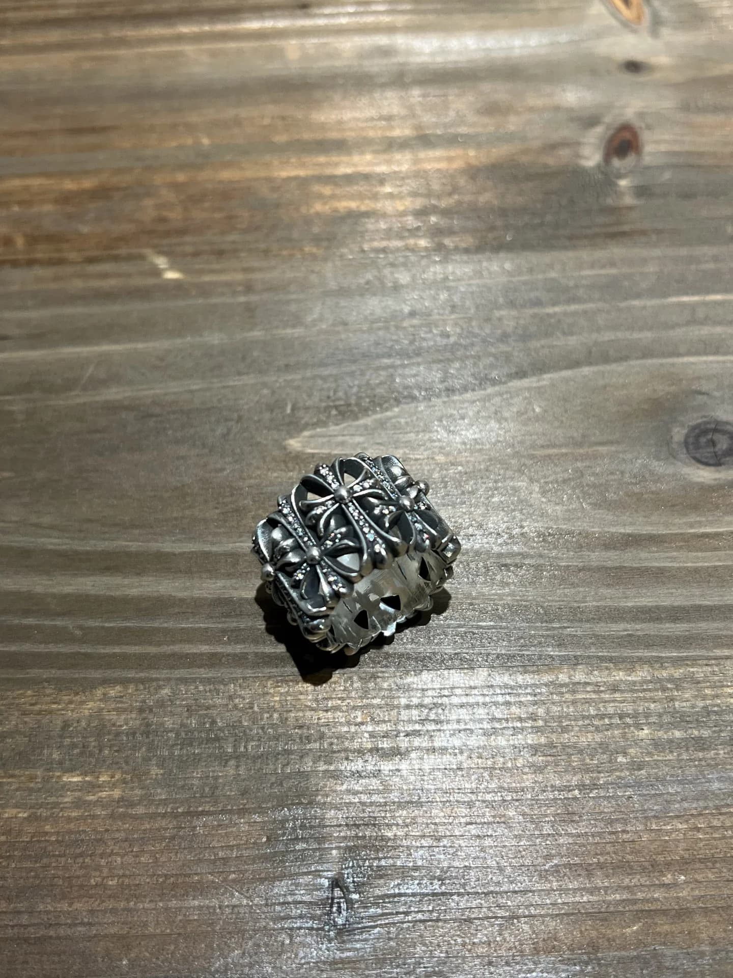 Серебряное кольцо Chrome Hearts Cemetery с инкрустацией бриллиантами на деревянной поверхности, вид сбоку