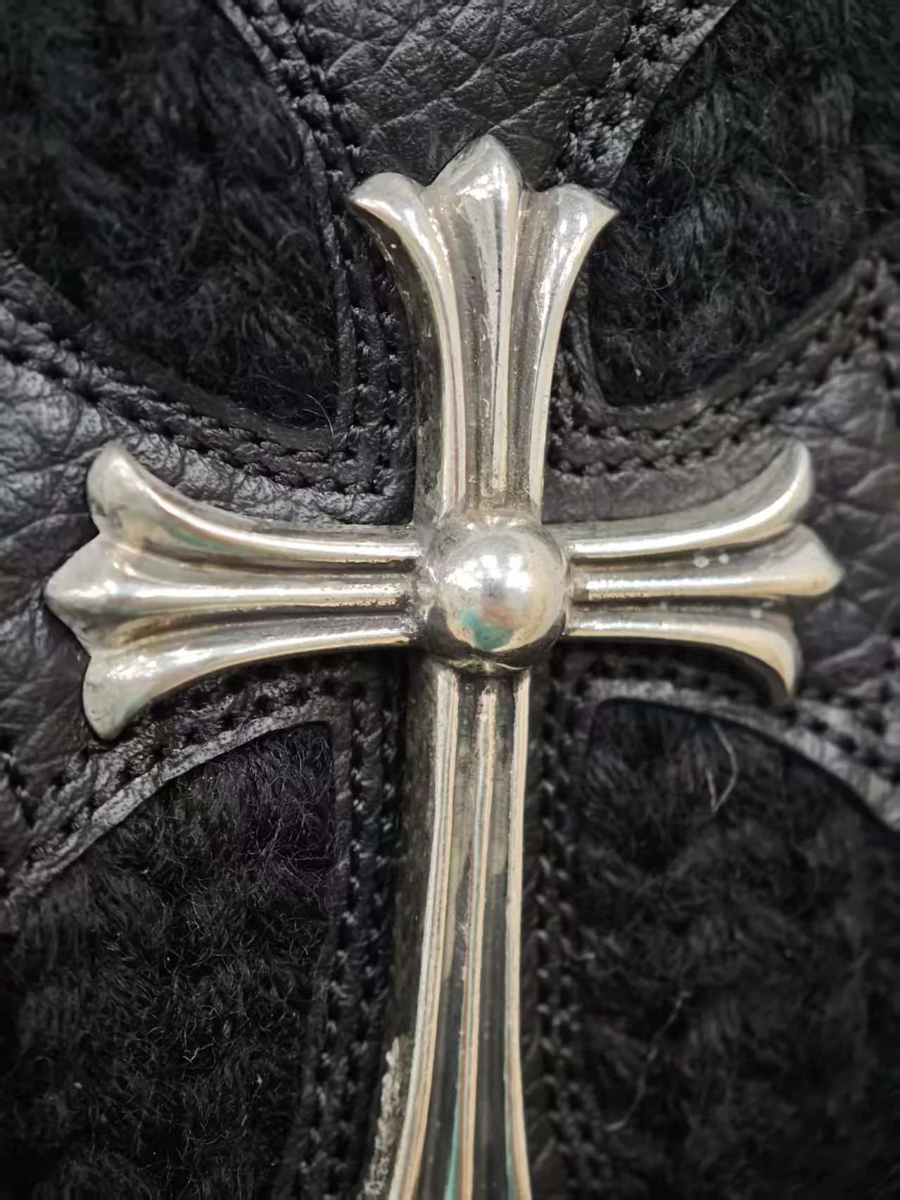 Крупный план серебряного креста на кашемировой шапке Chrome Hearts