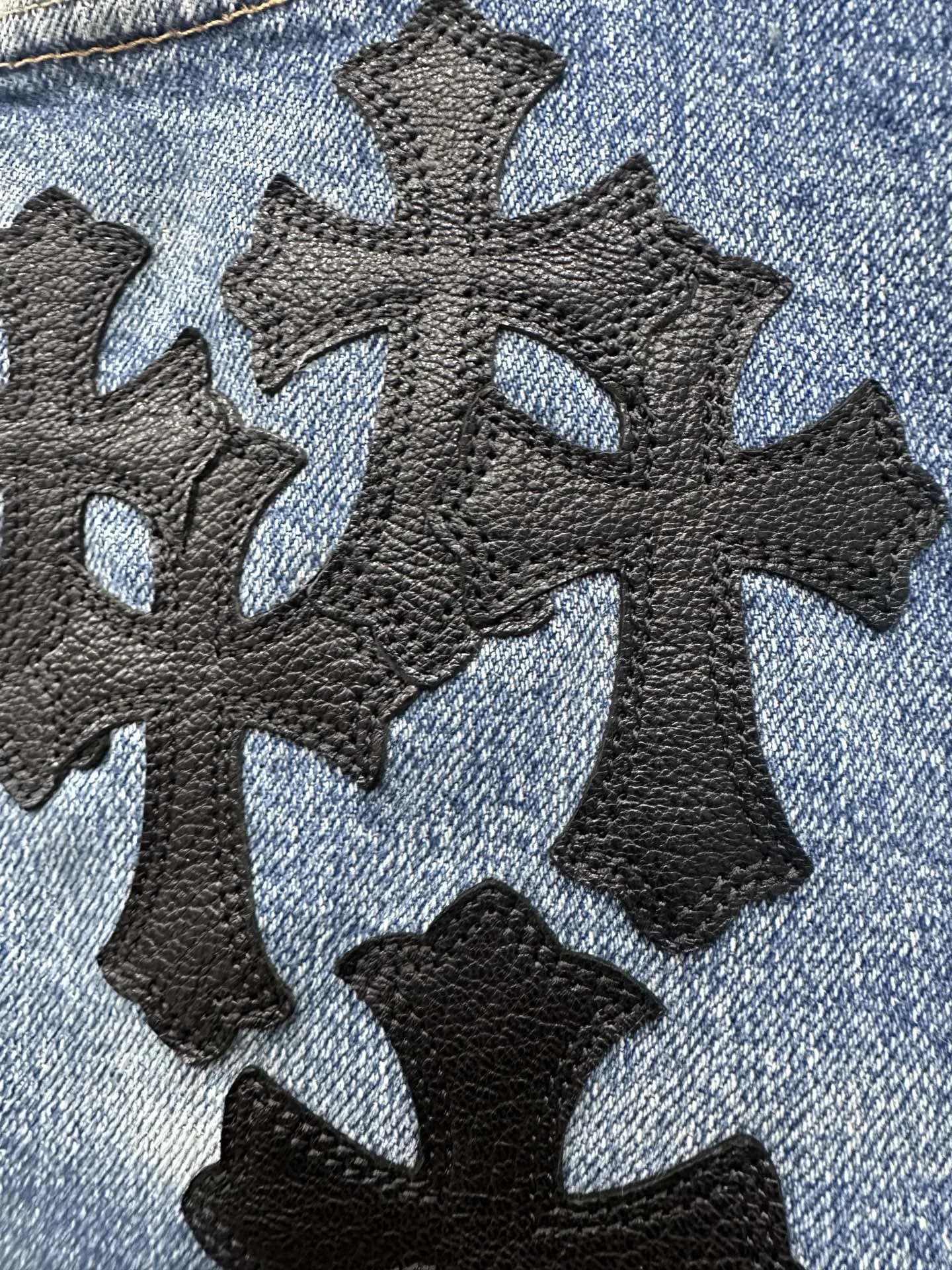 Деталь кожаных нашивок в виде крестов на джинсовой юбке Chrome Hearts