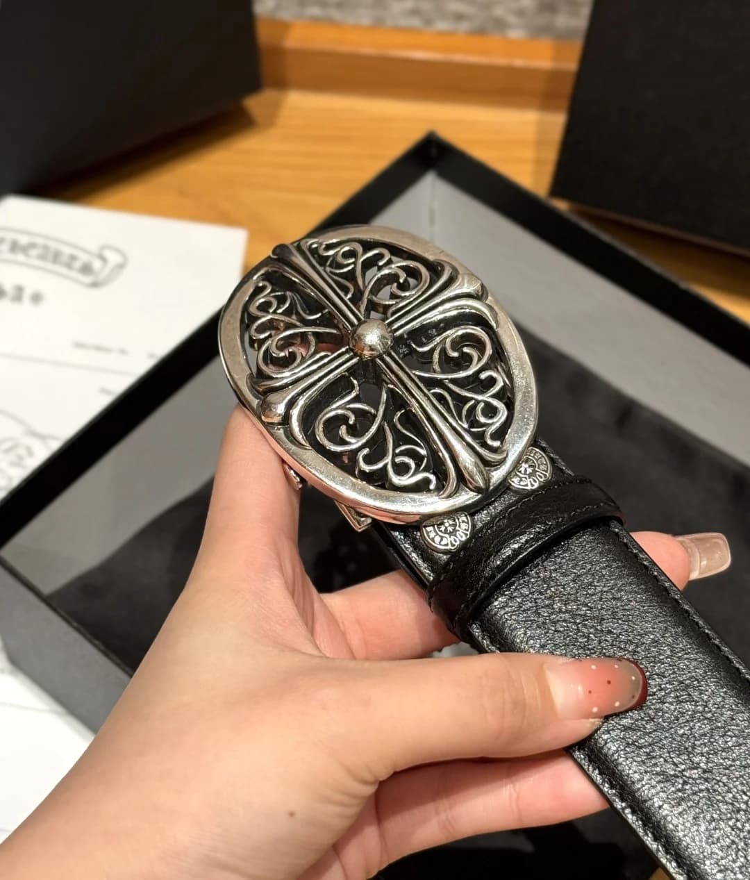 Крупный план массивной овальной пряжки Chrome Hearts со сквозным крестовым узором