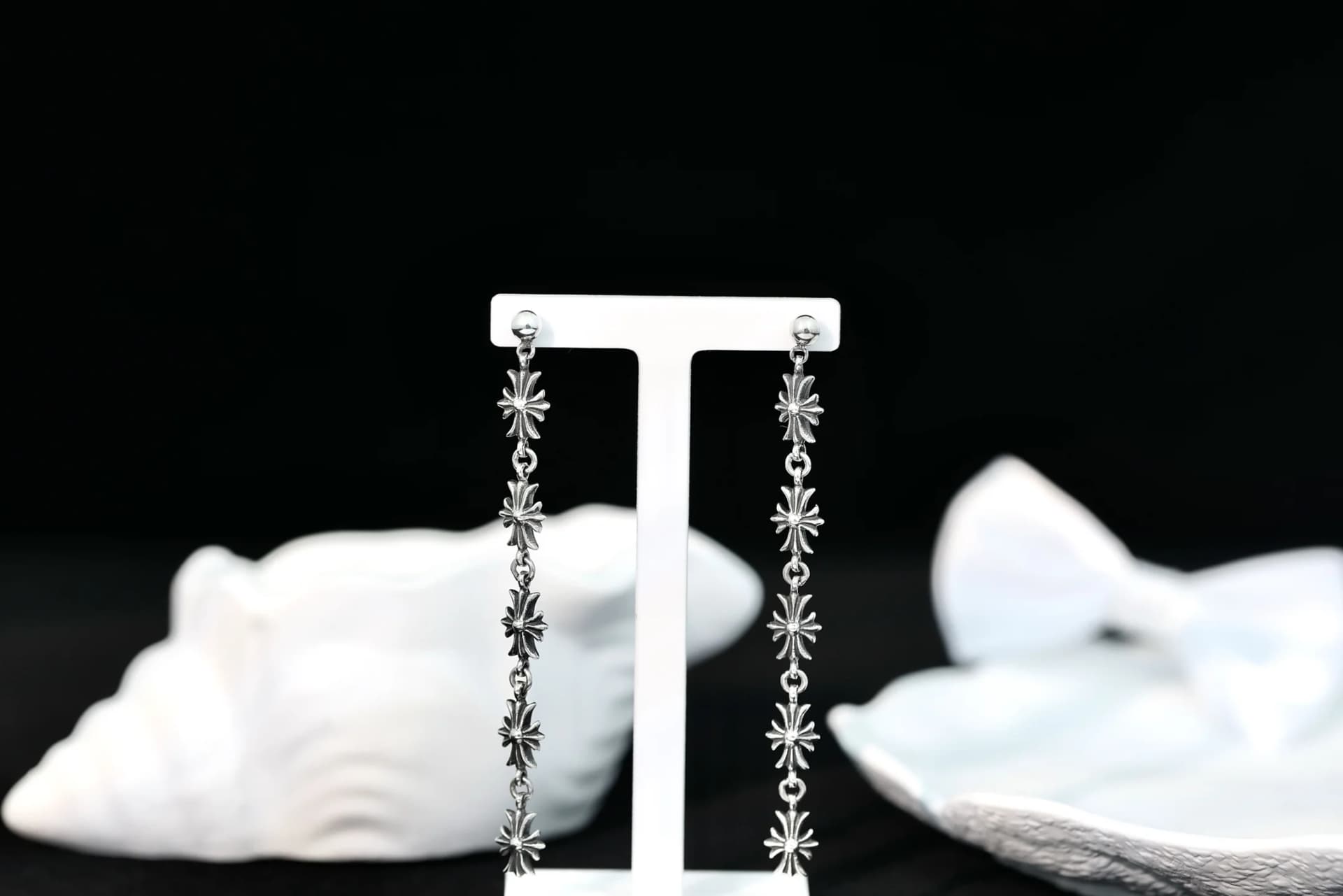 Длинные серебряные серьги Chrome Hearts Tiny E на демонстрационной стойке