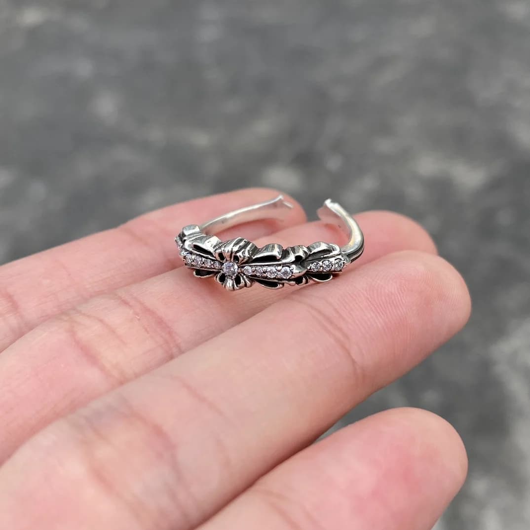 Открытое серебряное кольцо Chrome Hearts с кристаллами в руке под углом