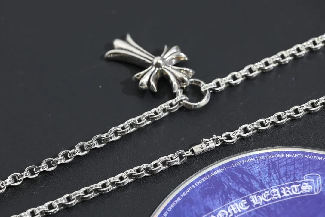 Крупный план подвески-креста и плетения звеньев цепи Chrome Hearts