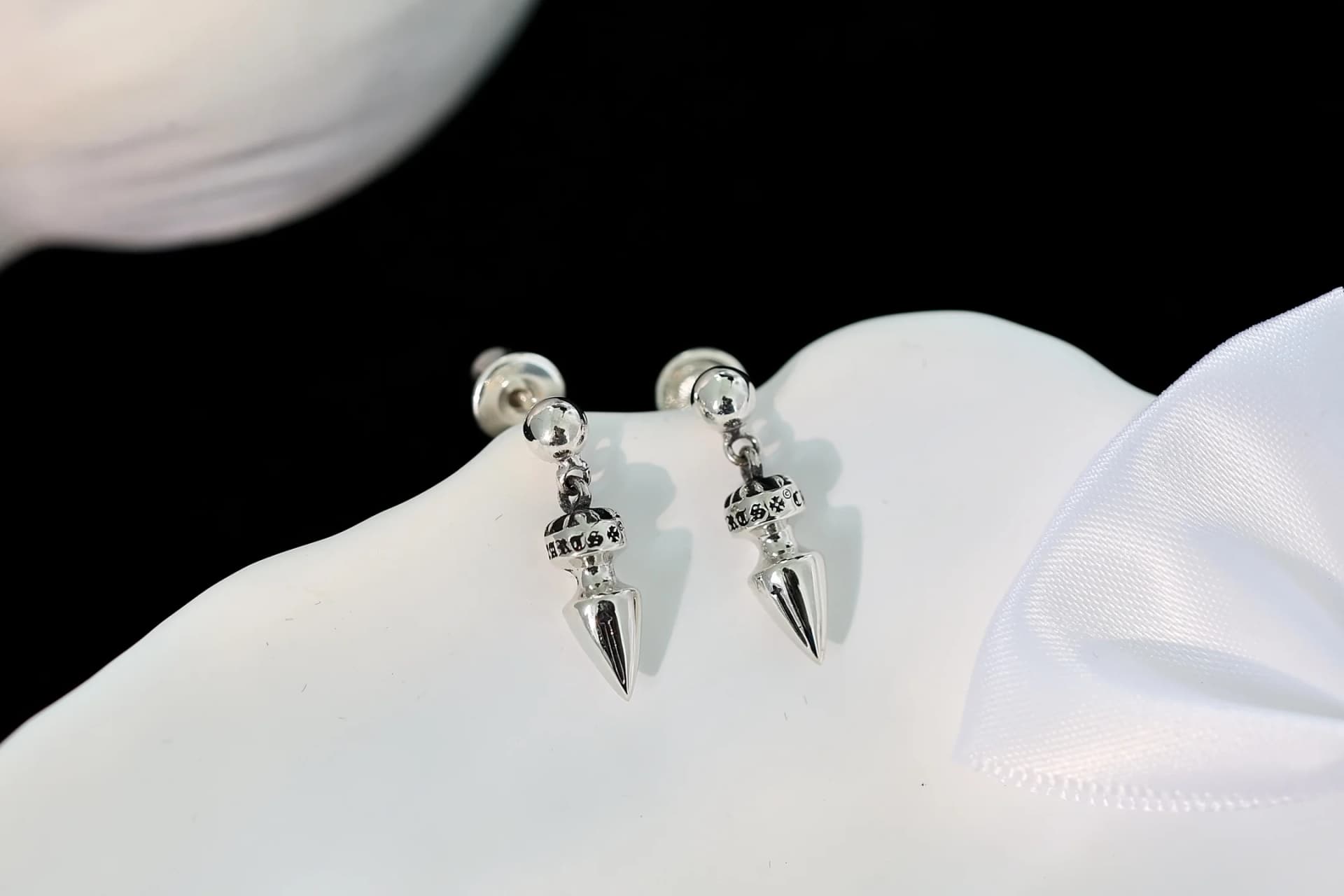 Серебряные серьги-пусеты Chrome Hearts с декоративным орнаментом на светлом фоне