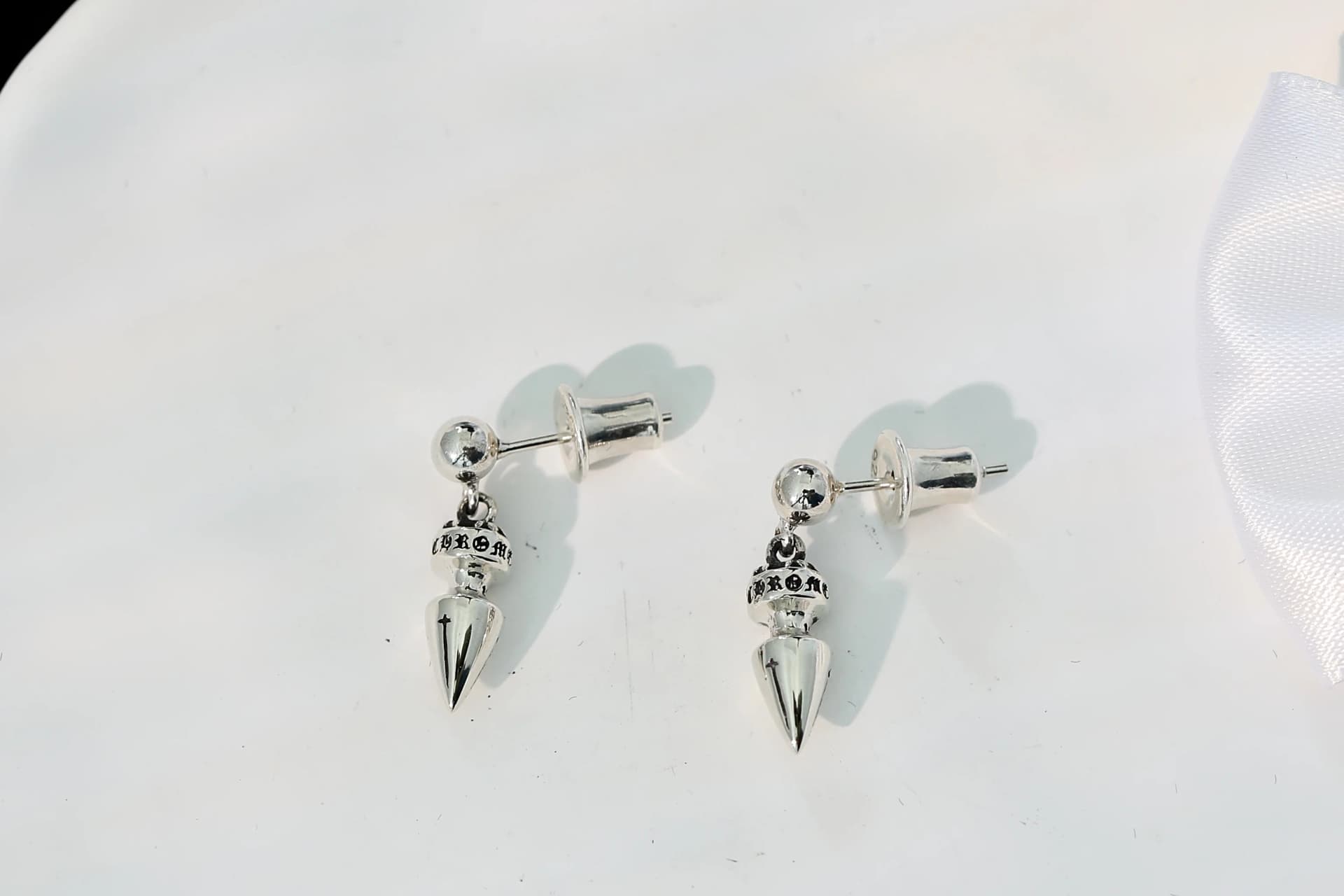 Пара серег-гвоздиков Chrome Hearts со стороны штифта и застежек-бабочек