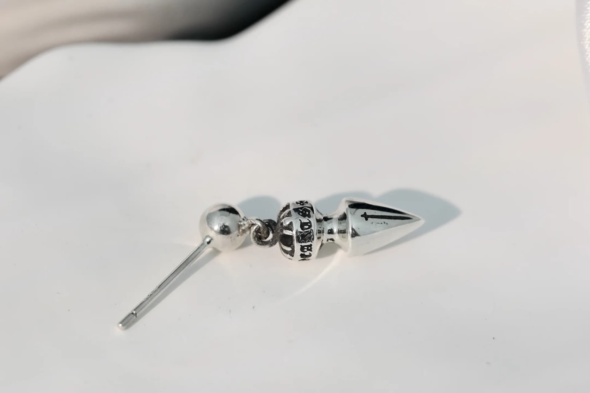 Серьга-гвоздик Chrome Hearts, вид сбоку с демонстрацией штифта и подвижного элемента