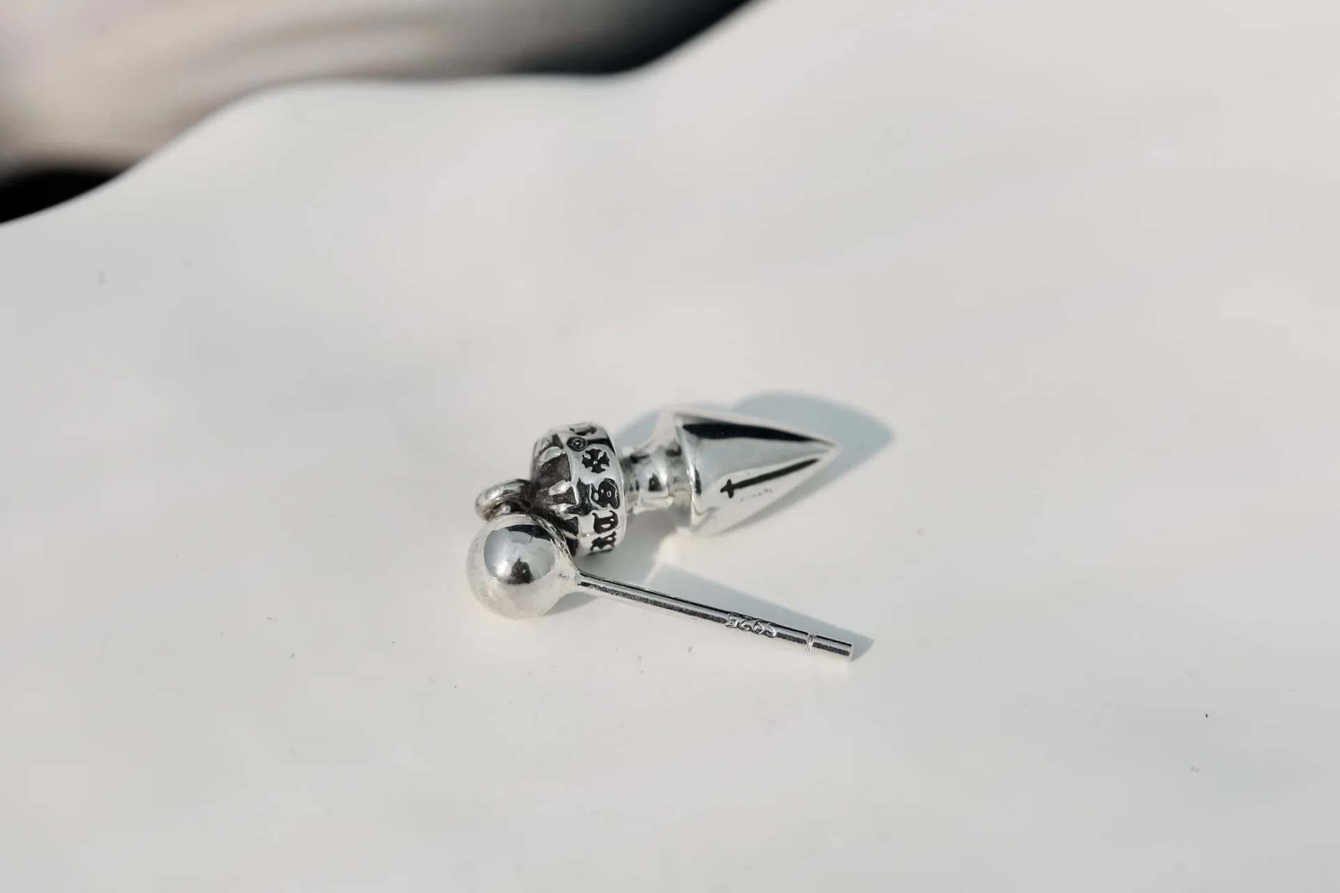 Деталь серьги Chrome Hearts: вид на гравированный шаровидный элемент и штифт