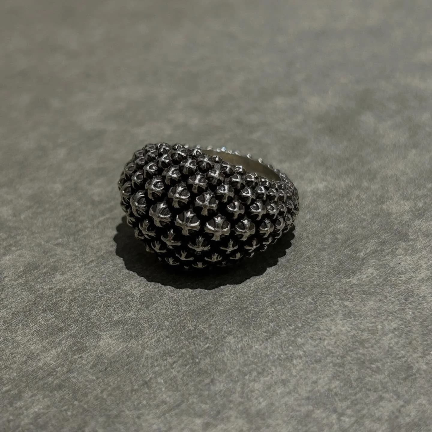 Серебряное кольцо Chrome Hearts с рельефным узором из крестов на сером фоне
