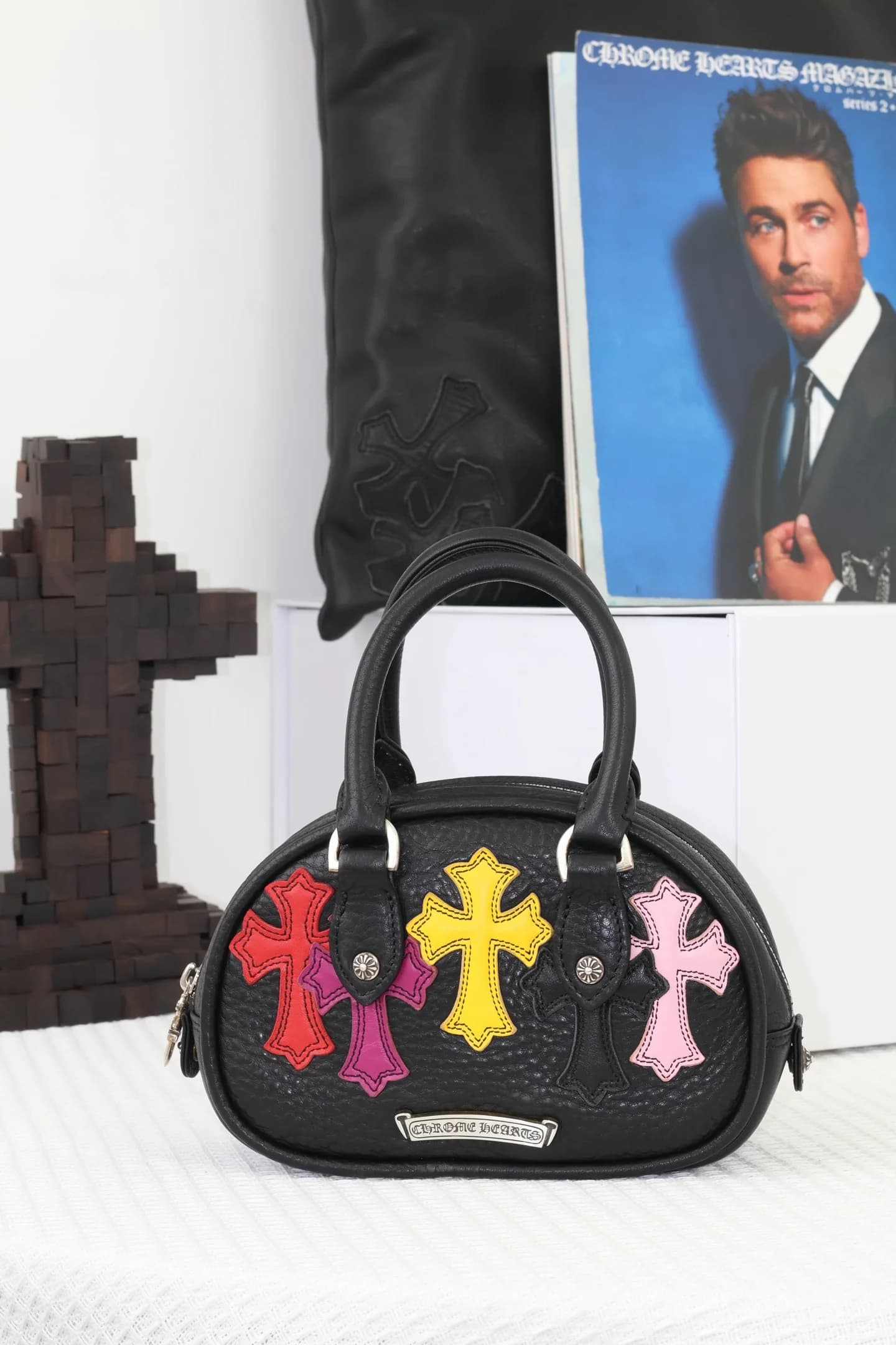 Сторона сумки Chrome Hearts с серебряной планкой-логотипом и цветными крестами
