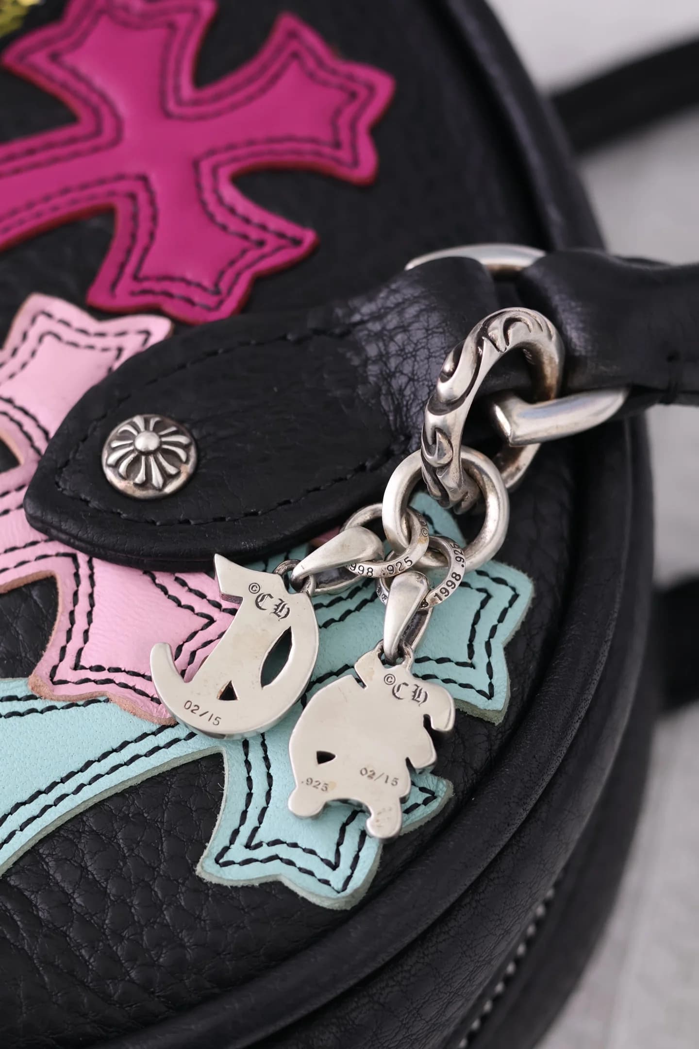 Фактура кожи, разноцветные нашивки крестов и серебряные подвески Chrome Hearts