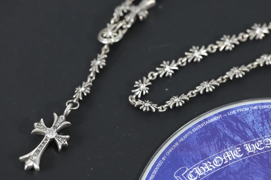 Крест с кристаллами и серебряная цепочка Chrome Hearts крупным планом