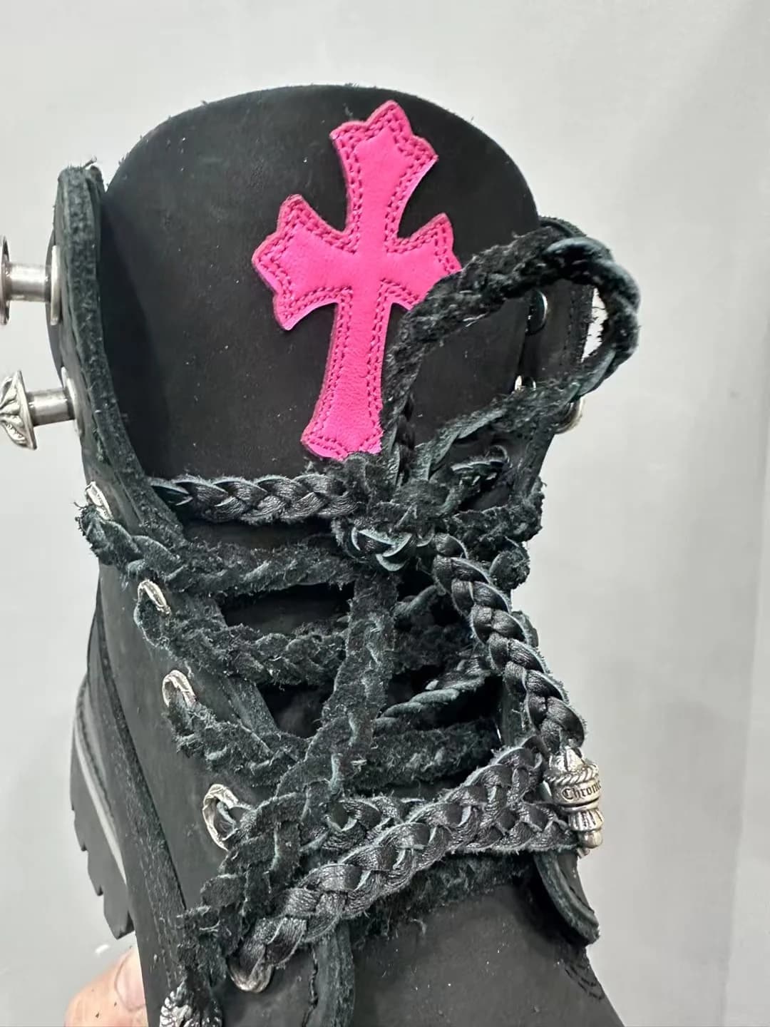 Деталь шнуровки и язычка ботинок Chrome Hearts с розовым крестом