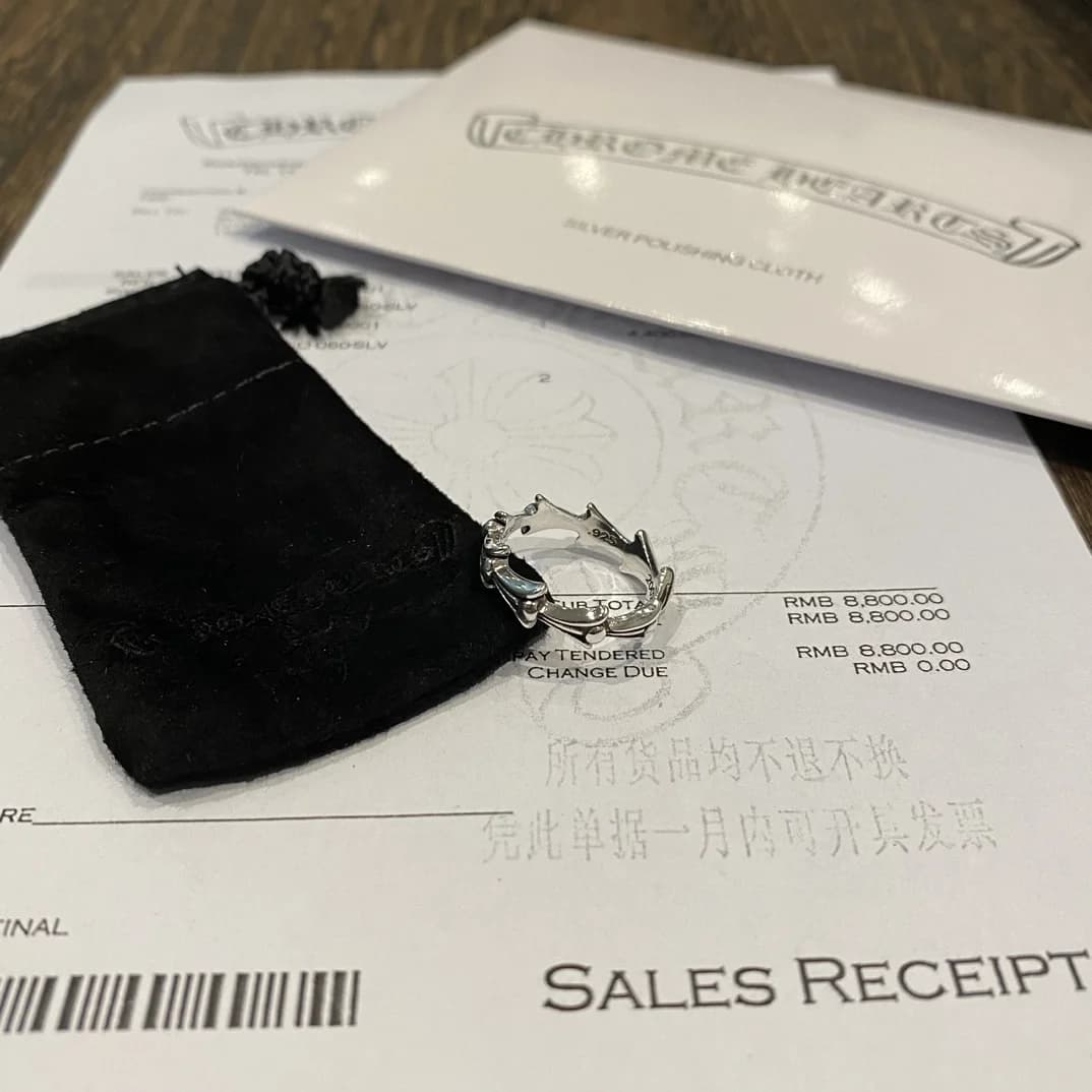Серебряное кольцо Chrome Hearts Crosstail рядом с фирменной салфеткой и чеком