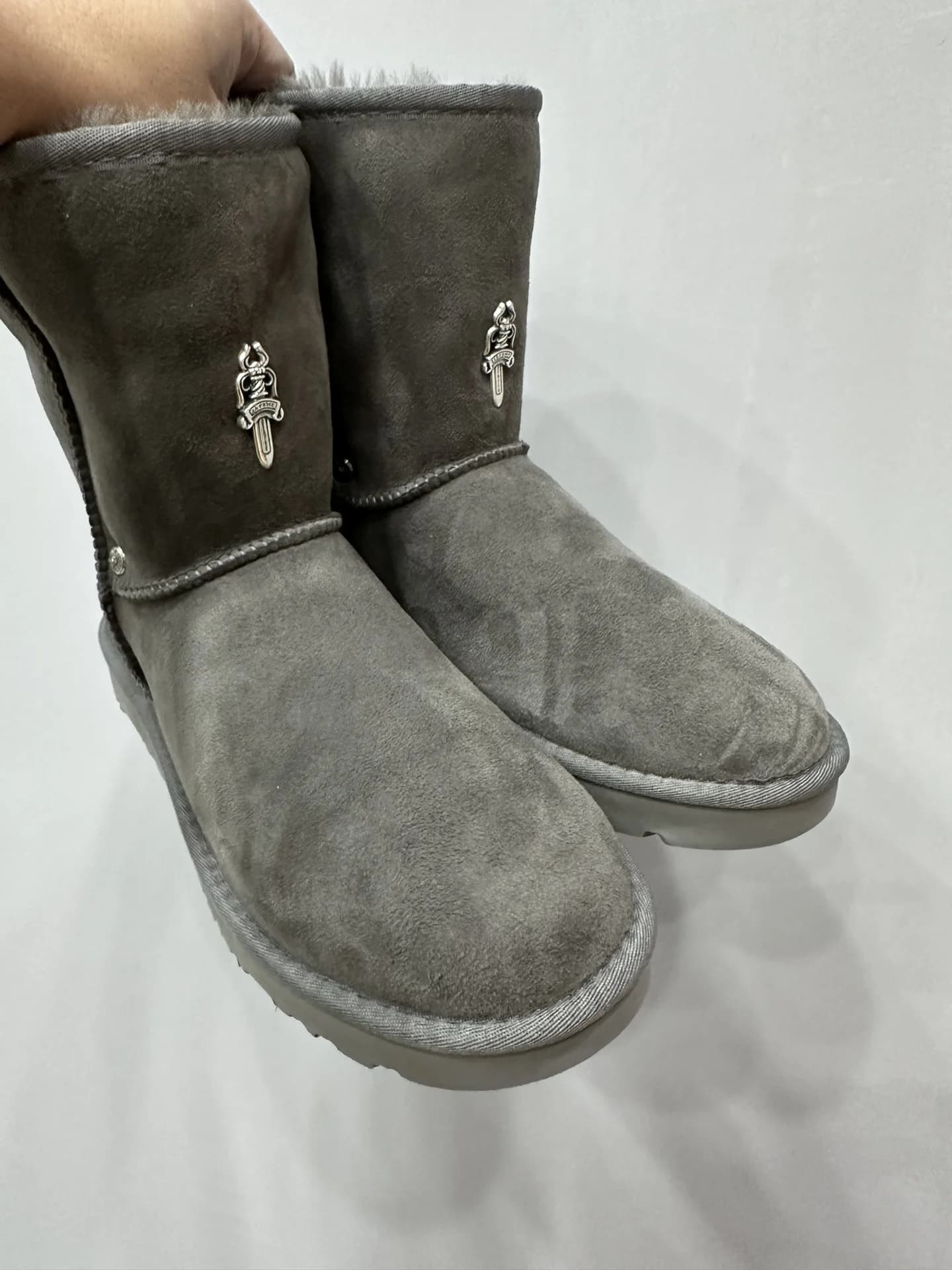 Серые замшевые сапоги-угги Chrome Hearts x UGG с серебристой фурнитурой-кинжалом, вид спереди