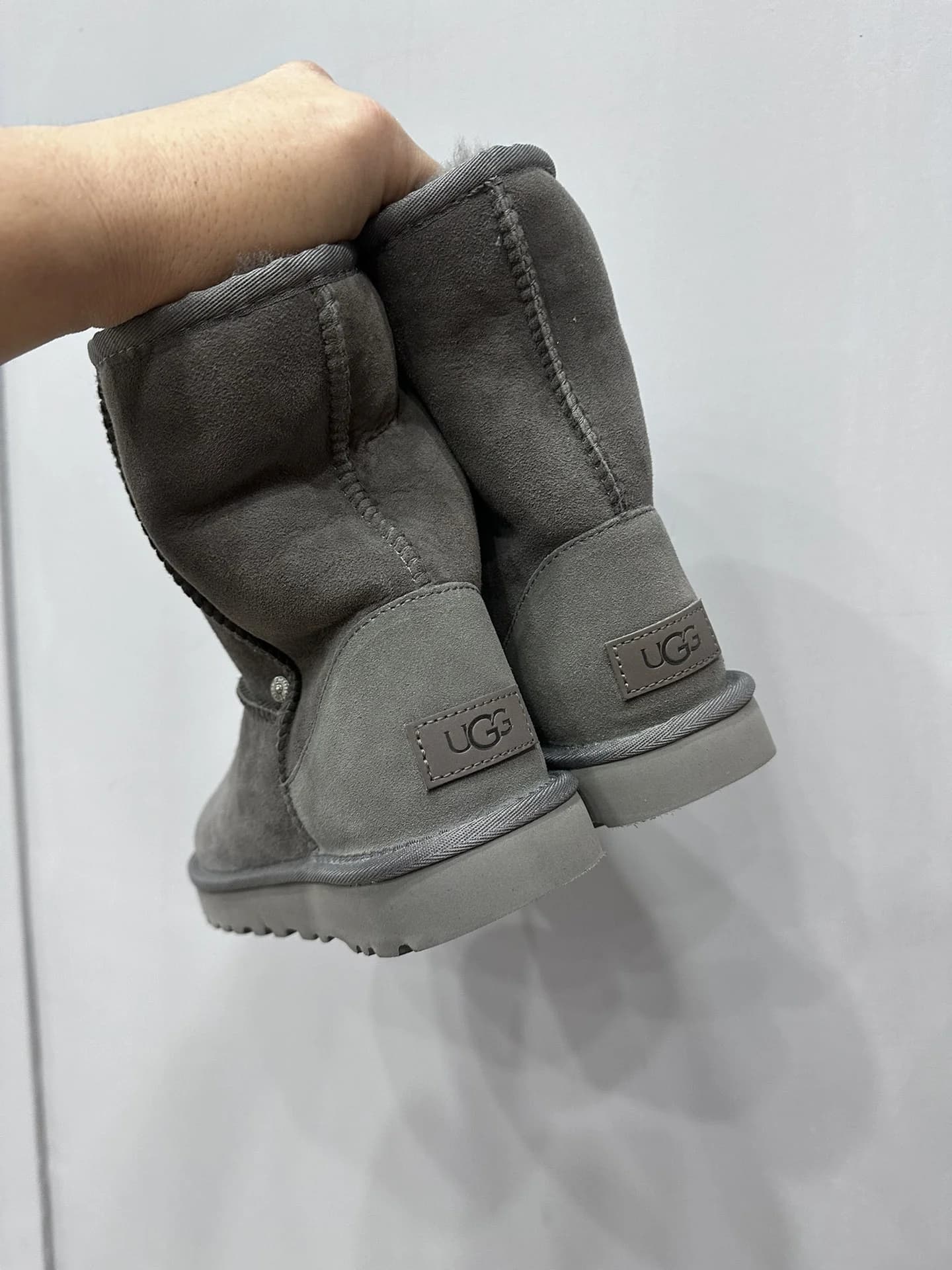 Задняя часть серых сапог-угги Chrome Hearts x UGG с нашивкой бренда на пятке