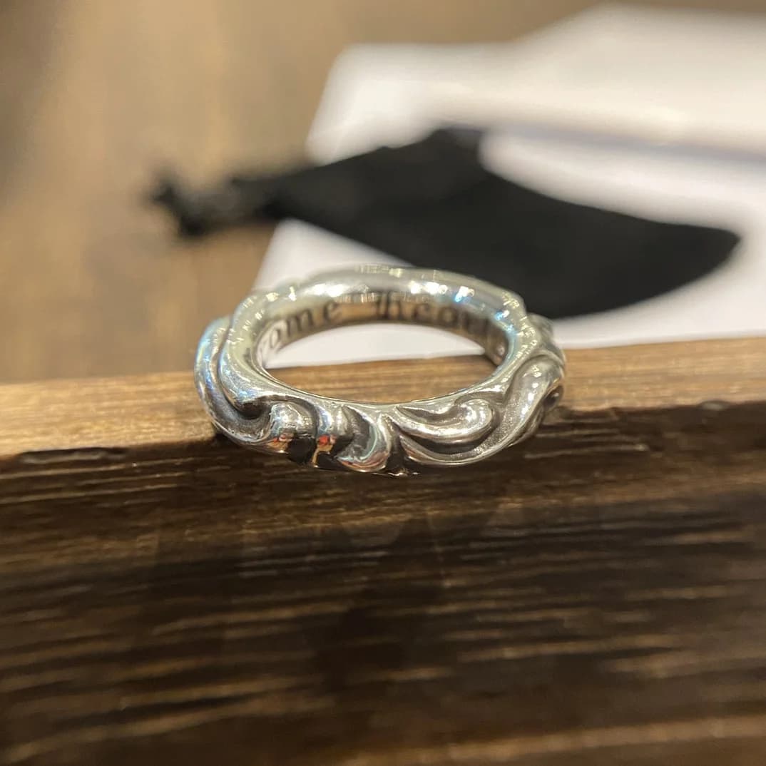 Серебряное кольцо Chrome Hearts Scroll крупным планом на деревянной подставке