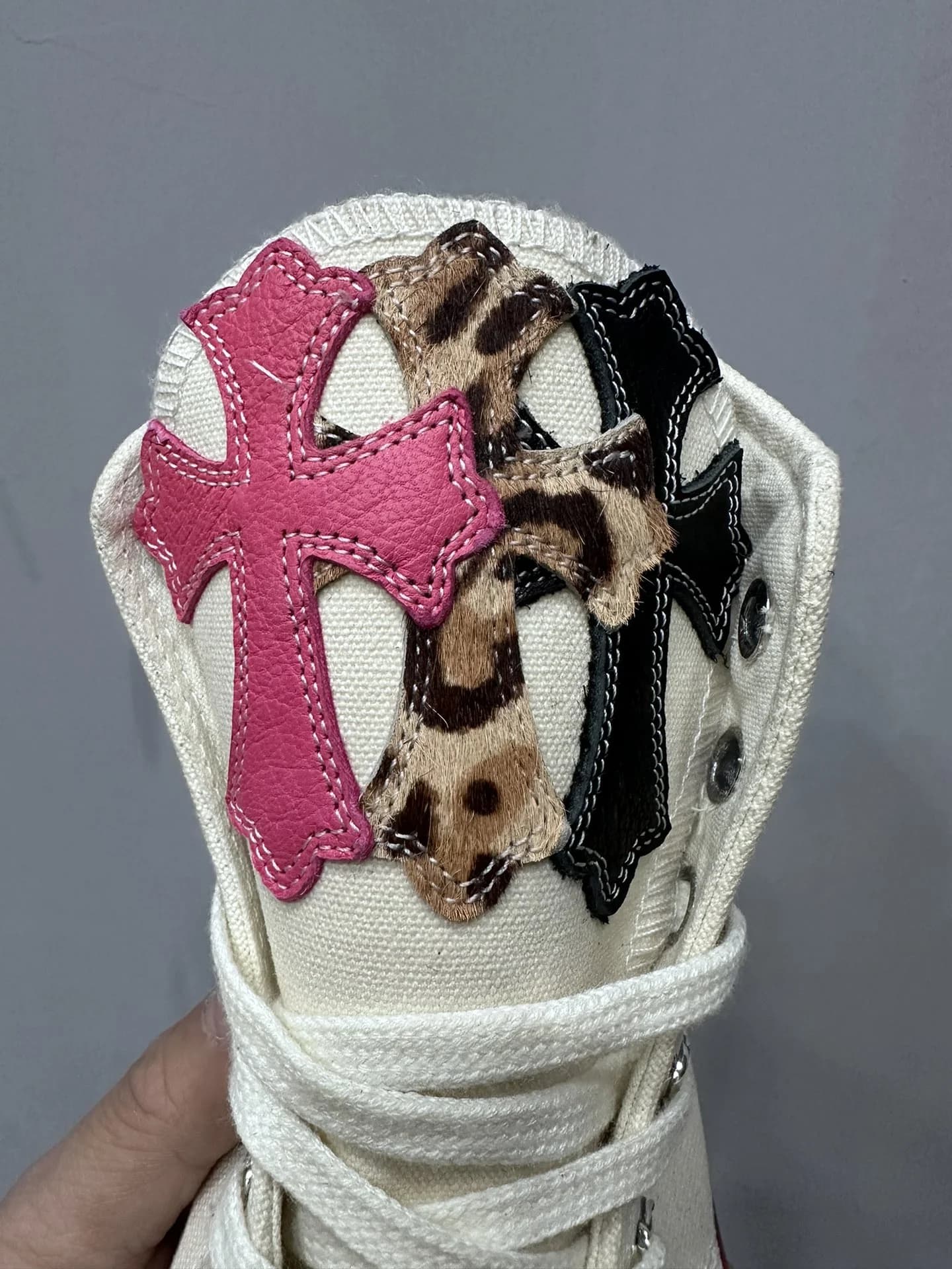 Крупный план кожаных нашивок в виде крестов на язычке кед Chrome Hearts x Converse Chuck 70