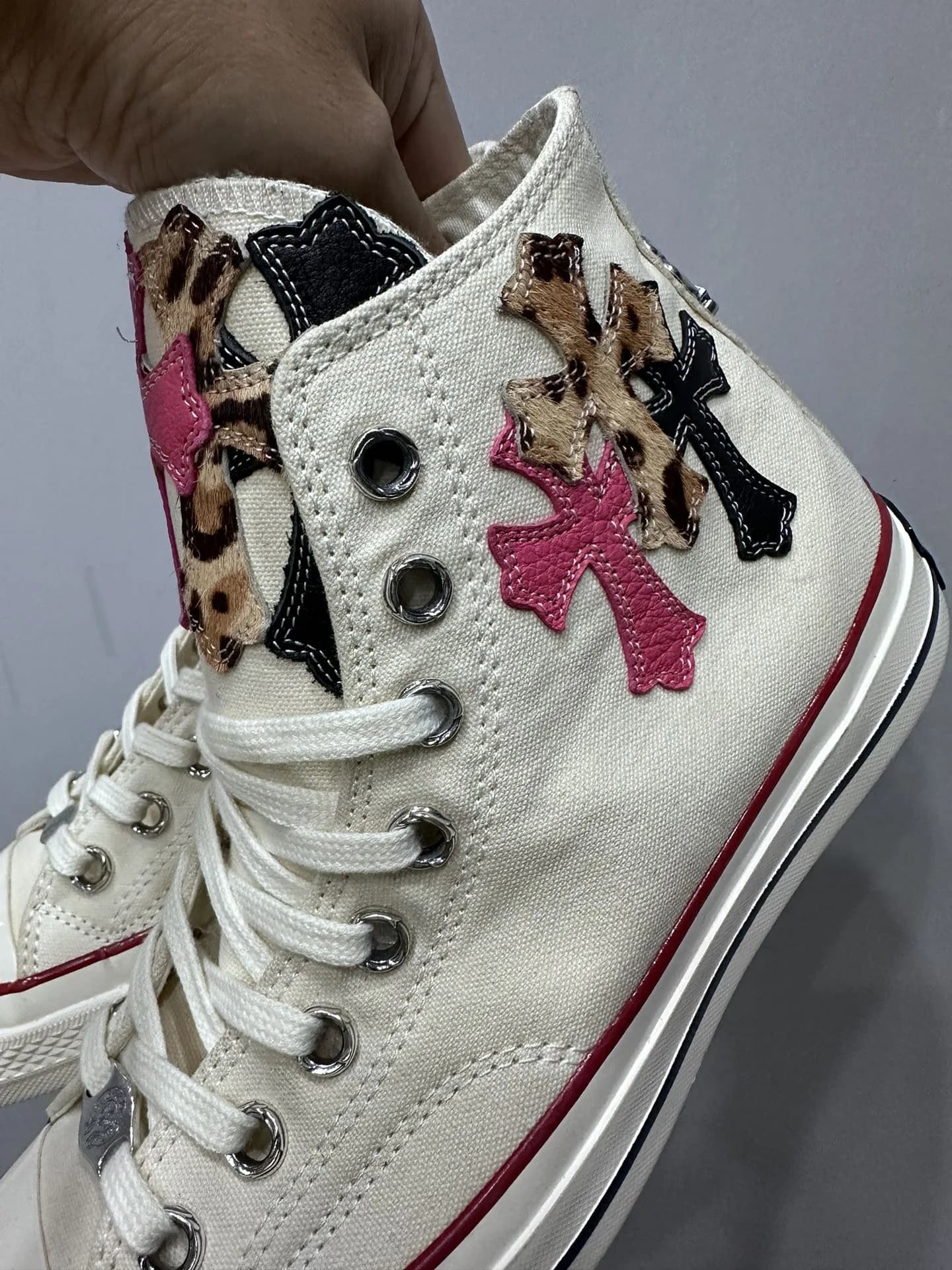 Вид сбоку на кеды Chrome Hearts x Converse Chuck 70 с леопардовыми и розовыми нашивками
