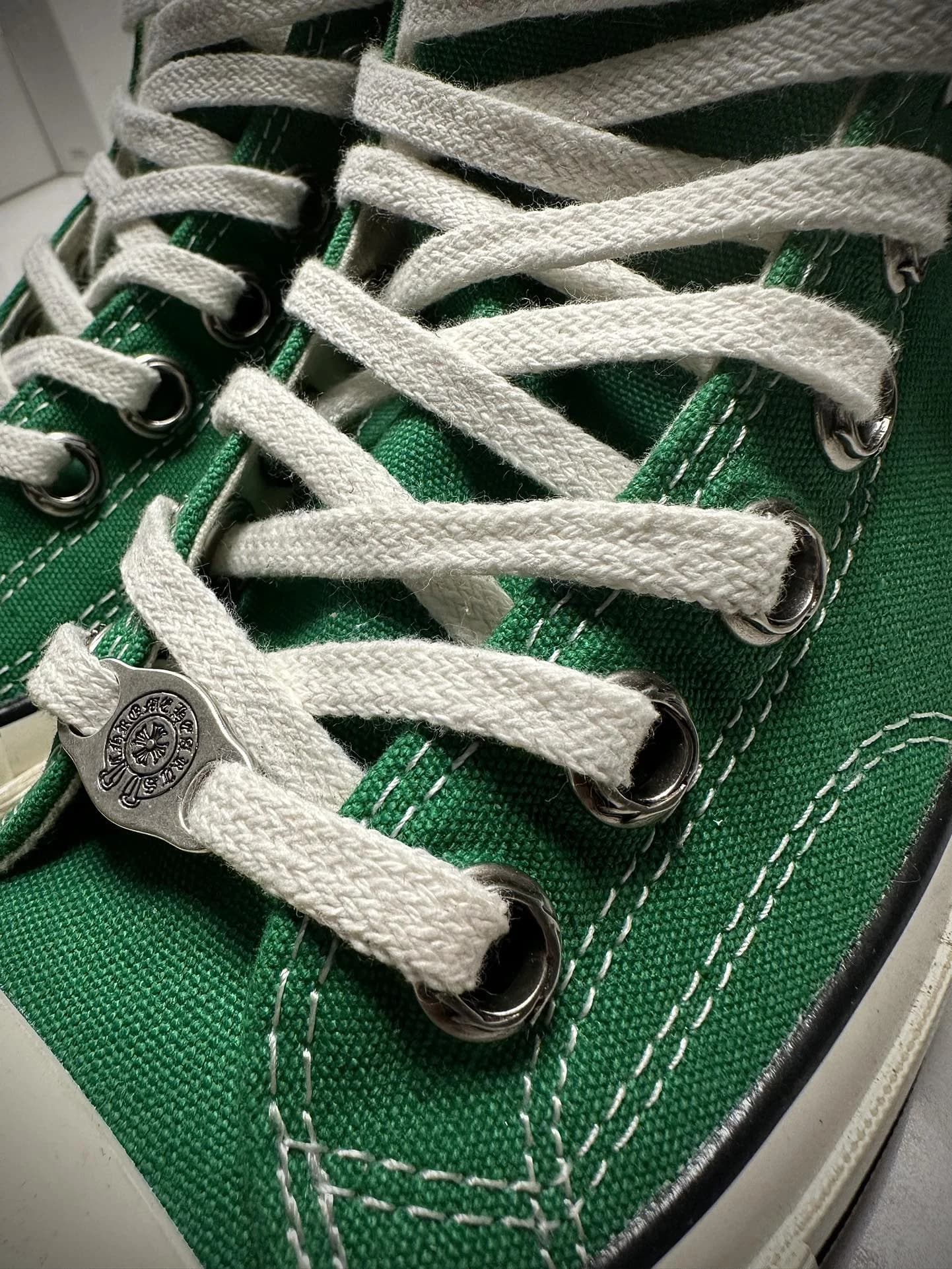 Деталь шнуровки зеленых кед Chrome Hearts x Converse Chuck 70 с серебряным элементом