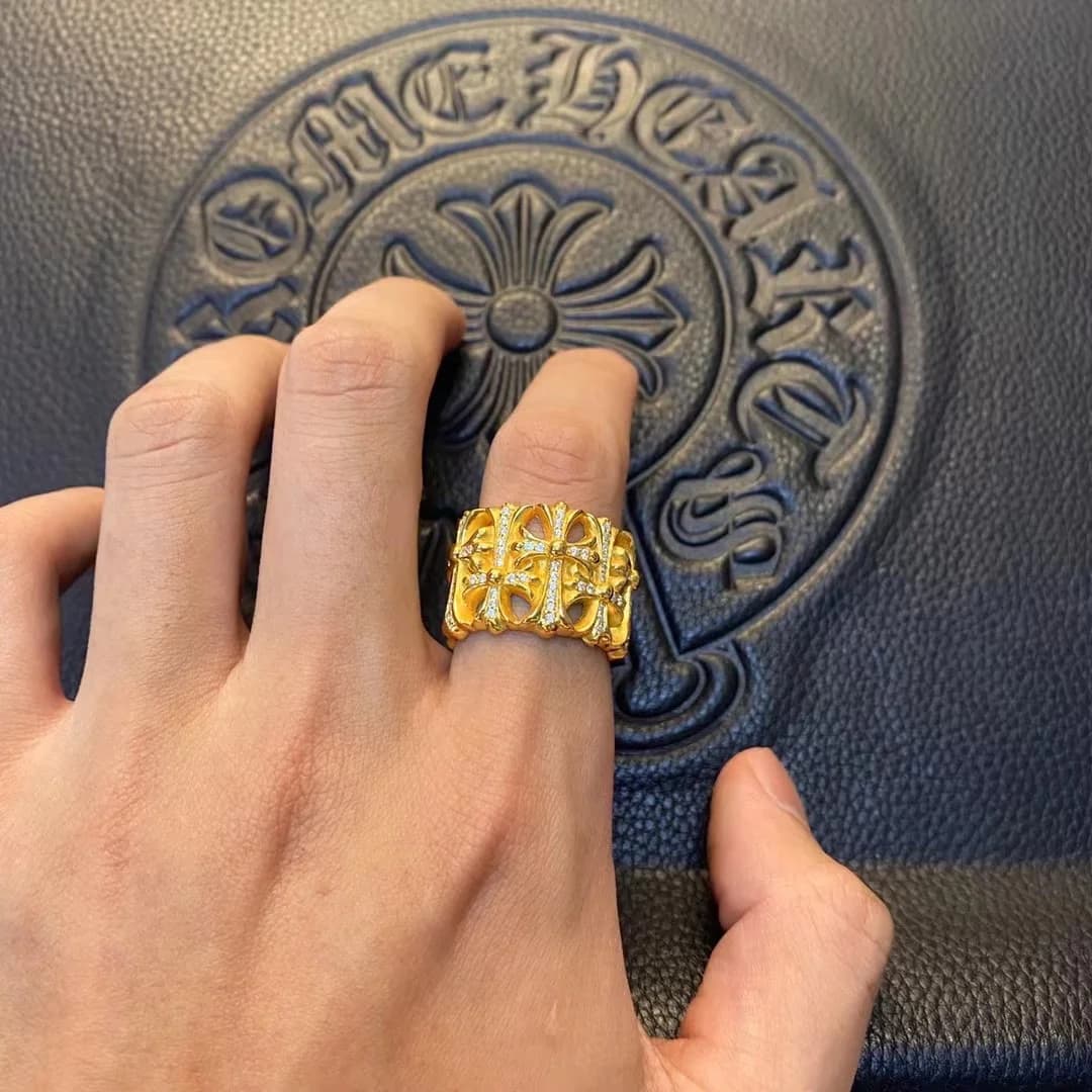 Золотистое кольцо Chrome Hearts Cemetery на пальце руки
