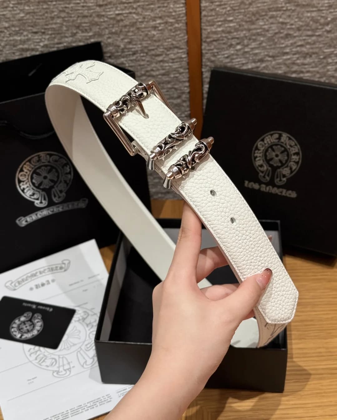 Белый кожаный ремень Chrome Hearts на фоне фирменной упаковки и комплекта