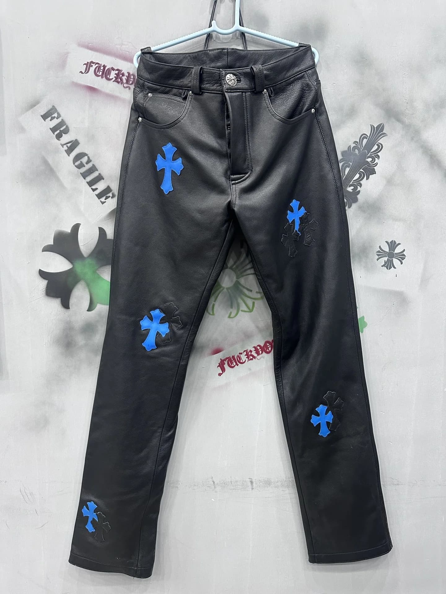 Черные кожаные брюки Chrome Hearts с синими нашивками-крестами, вид спереди