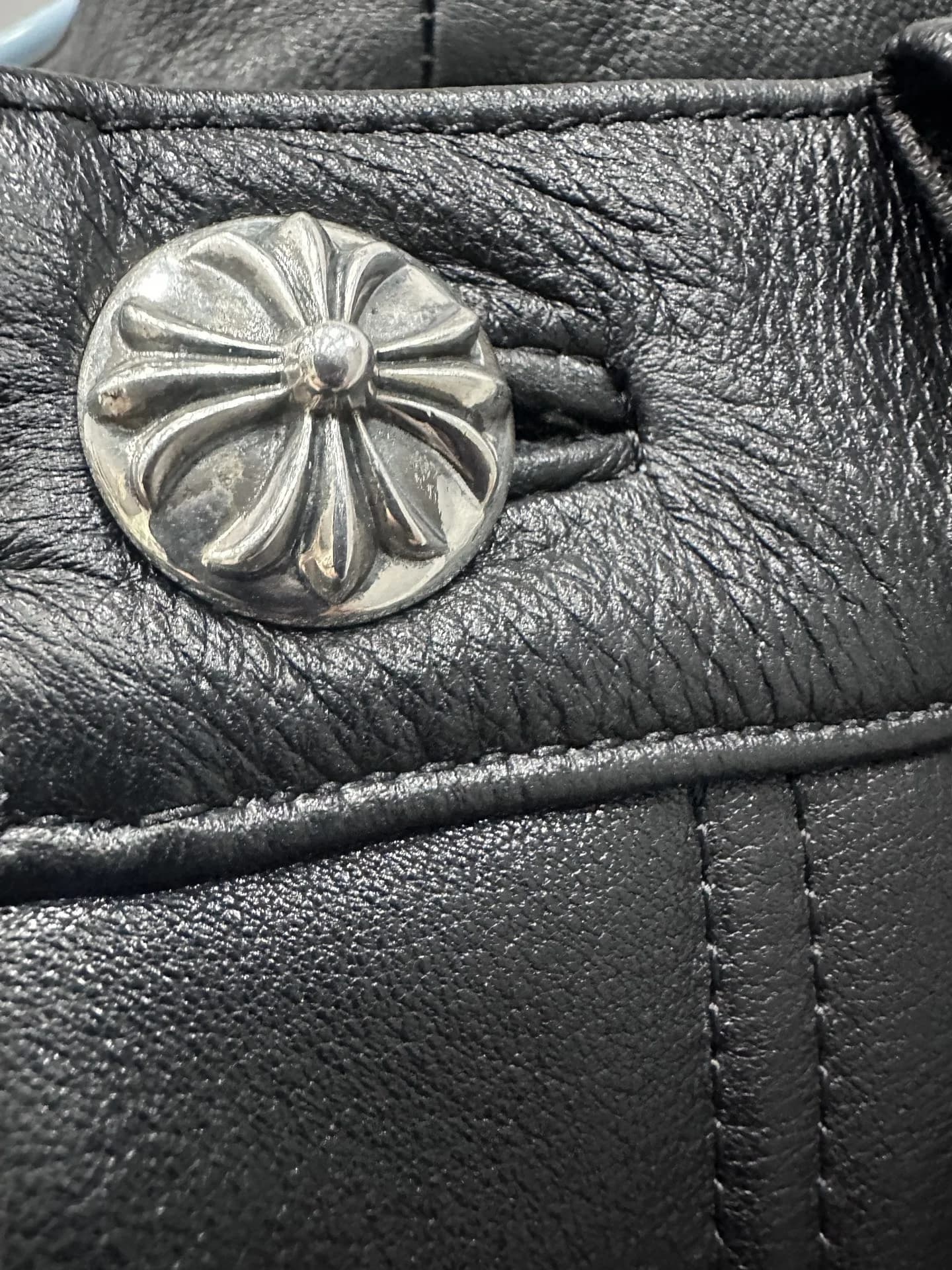 Серебряная пуговица с фирменным крестом Chrome Hearts на кожаных брюках